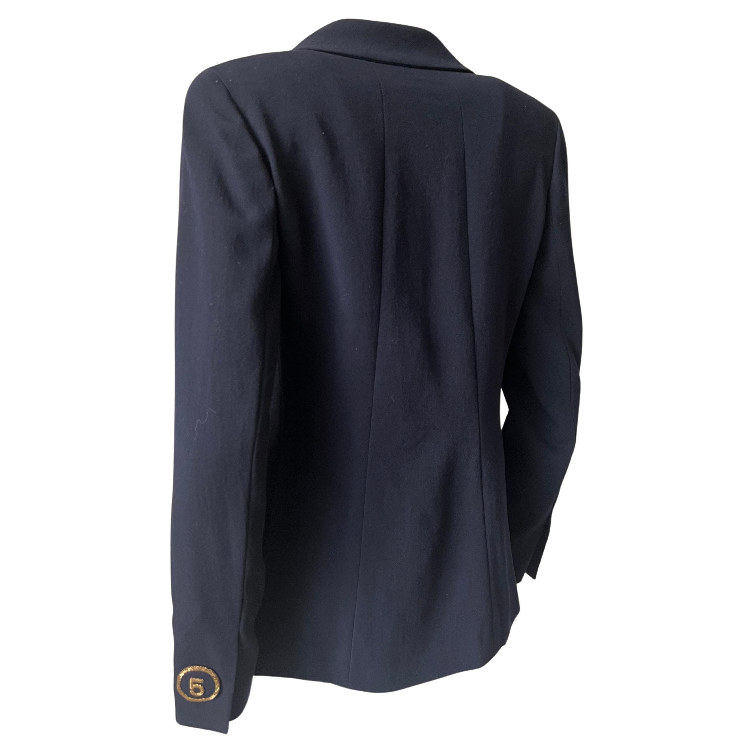 Pretty navy blue blazer, gold butt marked Chanel, shields embroidered with gold thread with brand logos on the back of each sleeve. Very elegant and timeless.