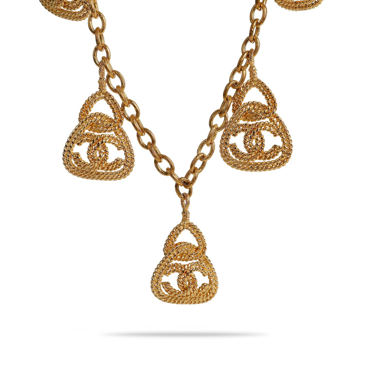 Diese authentische Chanel Gold CC Rope Charm Halskette ist in ausgezeichnetem Vintage-Zustand Form den späten 1980er Jahren.  Sieben ineinander greifende CC-Charms in einem verschlungenen Seil-Design baumeln an einer goldenen Gliederkette. 