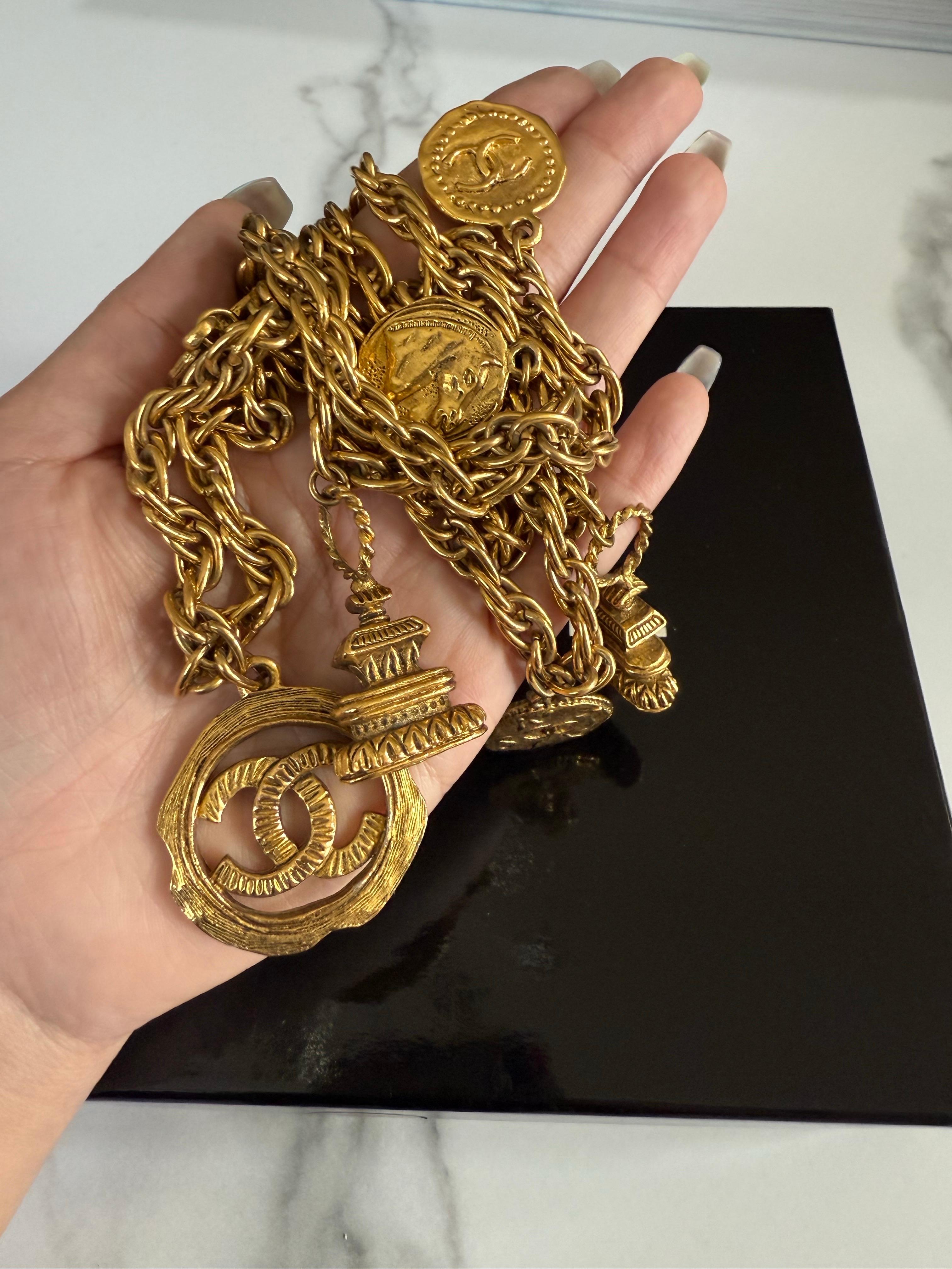 Collar de eslabones de cadena Chanel con colgantes que incluyen la clásica CC, la moneda de caballo, la moneda con logotipo grabado y los edificios con logotipo. Se puede llevar largo o doblado.
100% auténtico
Estampado CHANEL 
Fabricado en