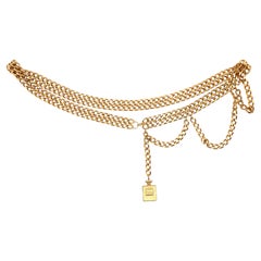 Cinturón vintage de Chanel de doble cadena dorada con colgante de perfume