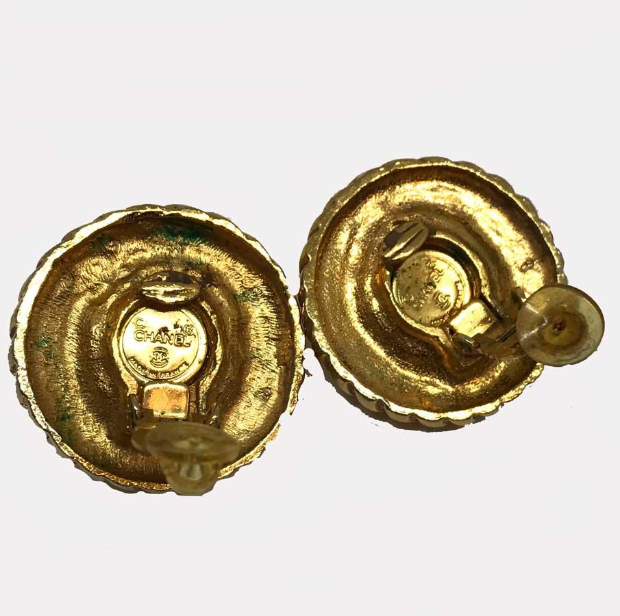 Zwei Kugeln aus gedrehtem, goldfarbenem Metall mit Perlmutt-Glaspaste in jeder Mitte.
CHANEL Clips sind Vintage und in sehr gutem Zustand. Sie besteht aus gedrehtem, goldenem Metall mit einer Perle aus Perlglassteinen und hat einen Durchmesser von 3
