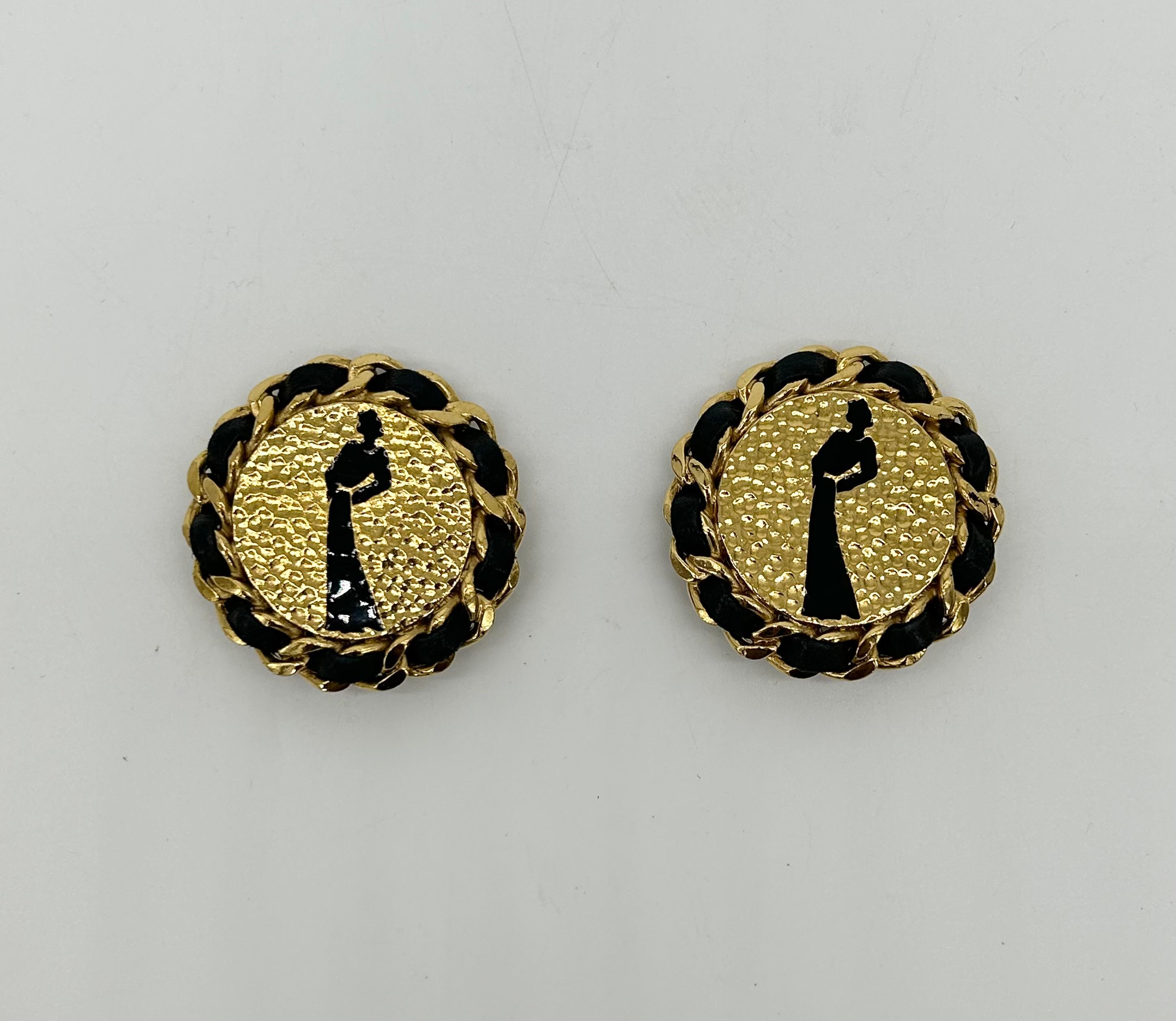 Chanel Vintage Gold Leather Chain Round Earrings In excellent condition. Large round gold earrings with black leather and chain edges and solid black enamel figure of woman standing in center front. Clip on backings. Excellent condition no scuffs or