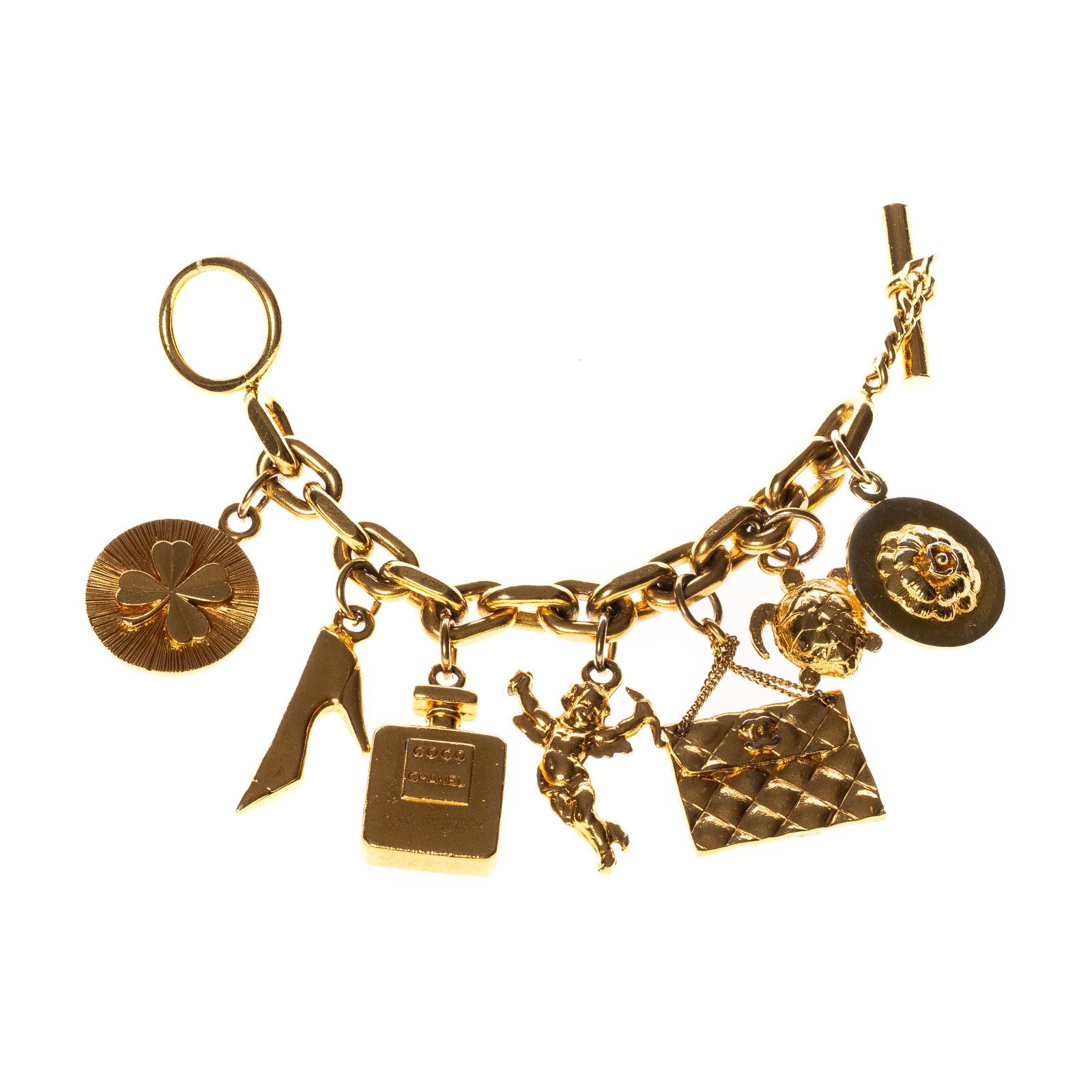 Chanel Glücksbringer 1980er Jahre goldfarbenes Armband mit ikonischem Chanel-Design. Goldfarbene Gliederkette mit sieben Anhängern, darunter Klee, Schuh, Parfümflasche, Amor, gesteppte Chanel-Handtasche, Schildkröte und Kamelienblüte, gestempelt