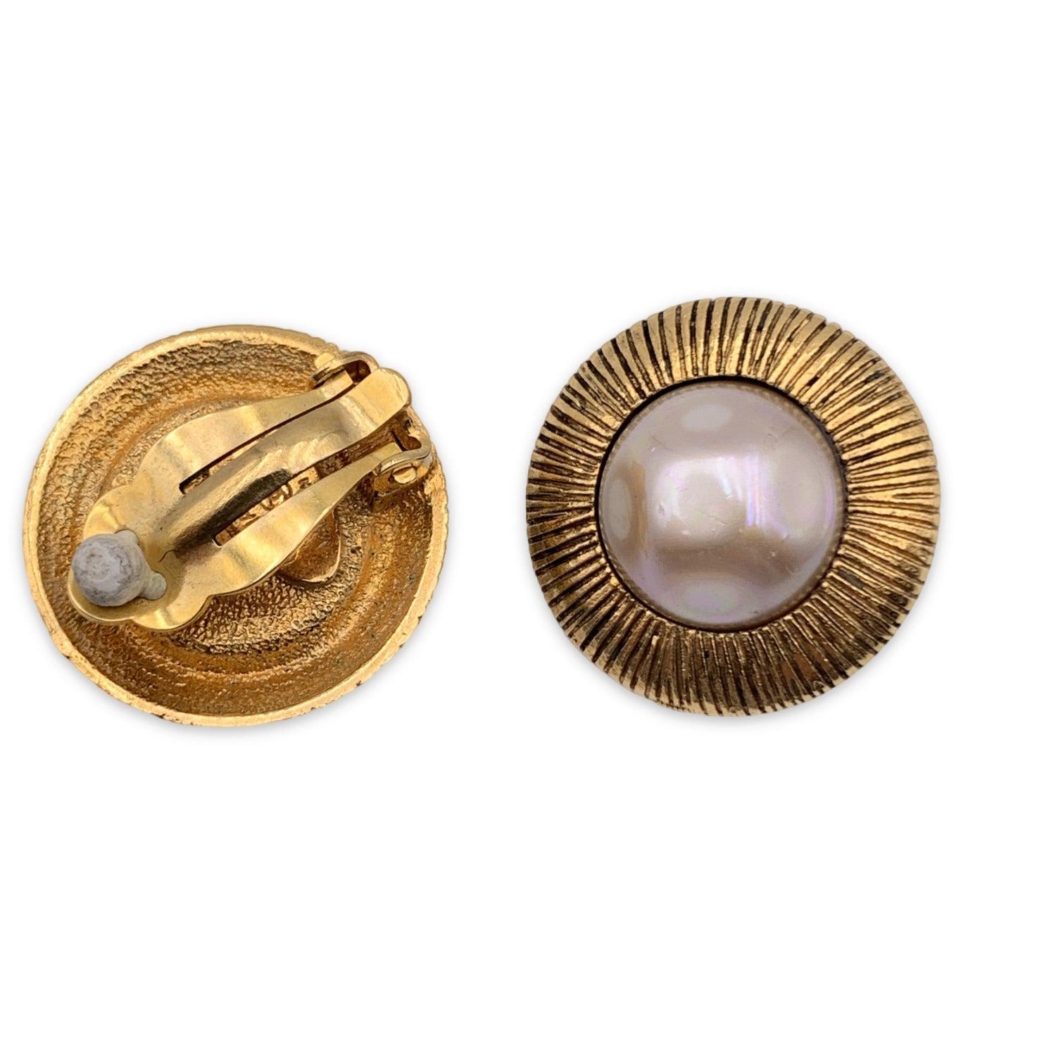 Timeless elegance in miniature form-these gorgeous vintage CHANEL earrings are a testament to the maison's signature blend of refinement and bold design. Crafted in a luminous faux pearl nestled within an engraved round gold-tone metal frame, each