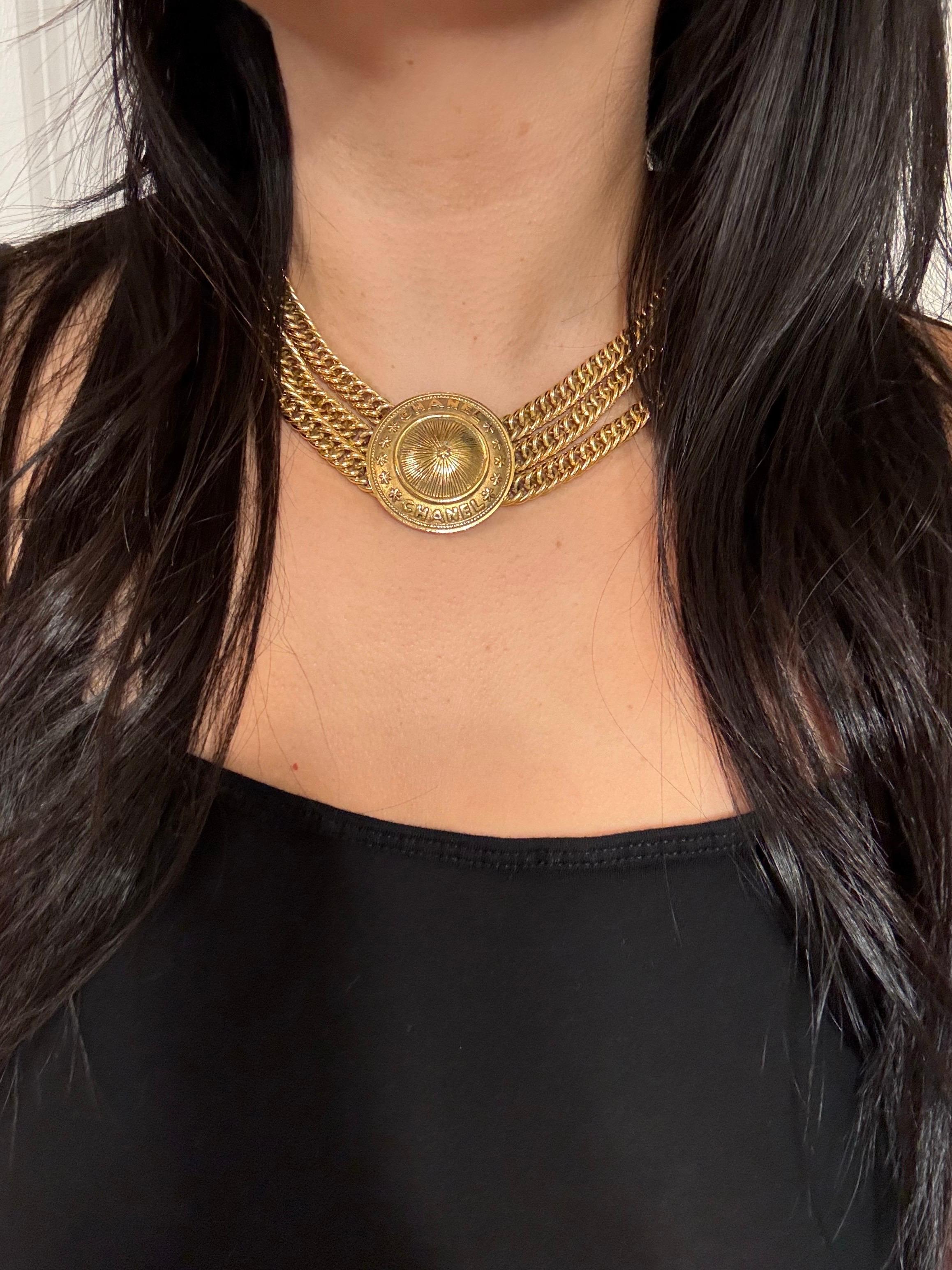 Dettagli:
La collana Chanel vintage, risalente ai primi anni '90, presenta tre catene placcate in oro 24k con un grande medaglione rotondo placcato in oro 24k al centro. Il ciondolo ha un motivo a stella al centro. La collana ha una chiusura a