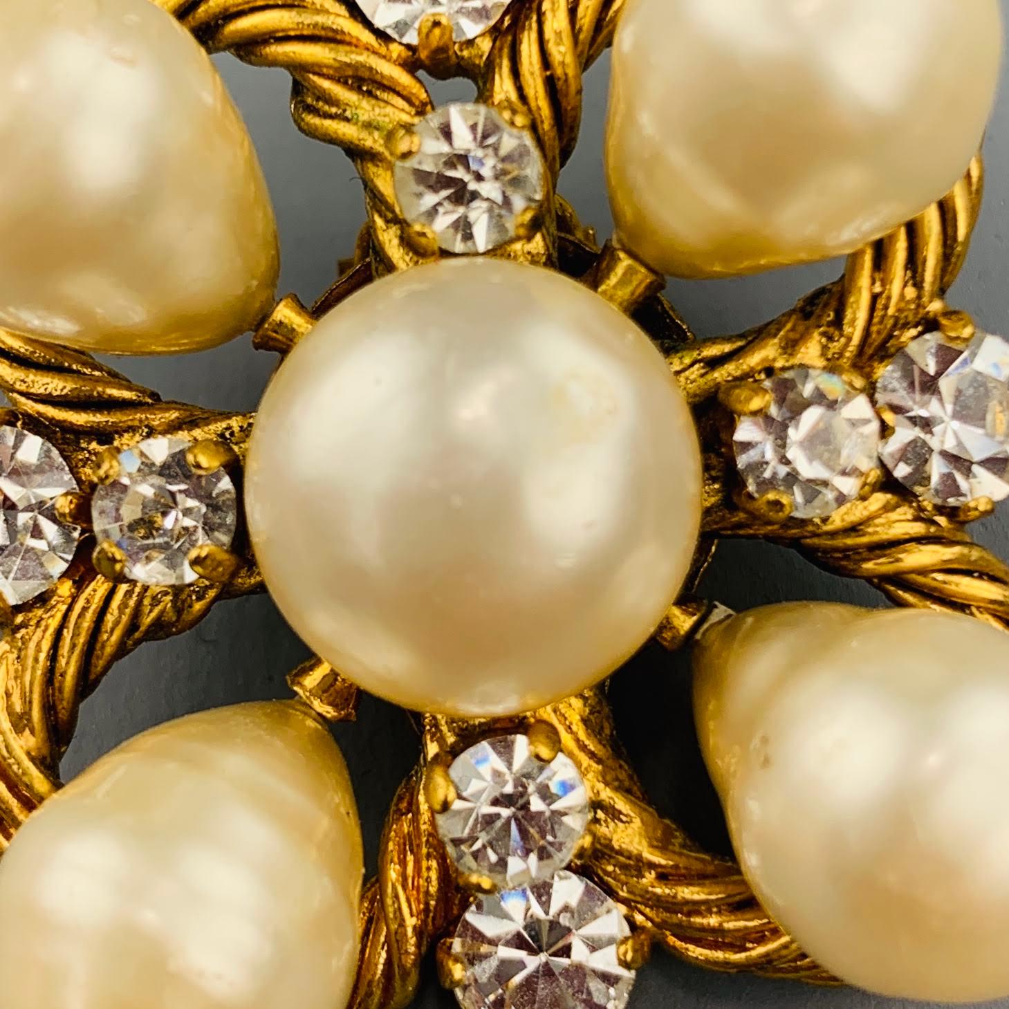 Vintage CHANEL Season 29 (Circa 1986-1992) clip on earrings come in yellow gold tone twist textured metal in a cluster formation with clear rhinestones and round and teardrop faux pearls. Made in France.
 
Very Good Pre-Owned Condition.
Marked: 29
