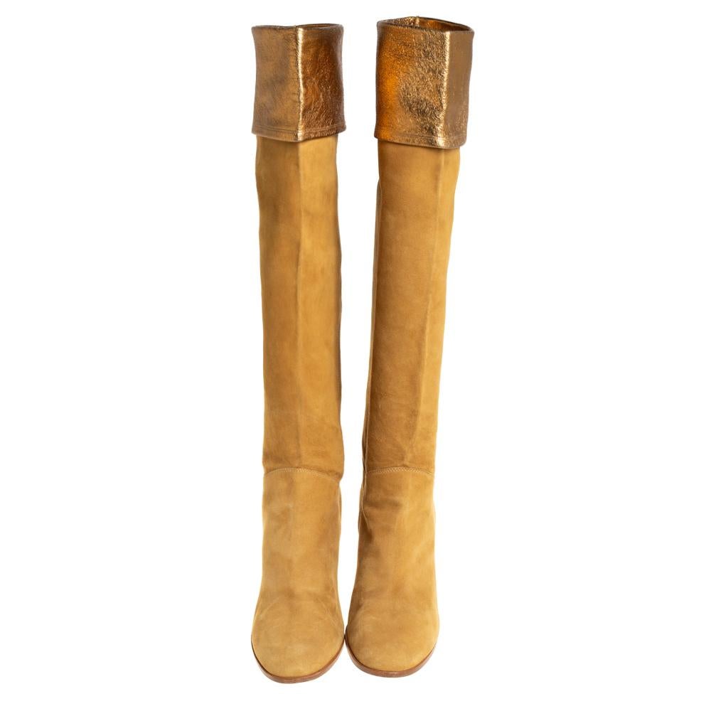 Chanel never fails to design classic styles that become favorites in one's closet. These gold knee-length boots for women are a fine example. Made from suede, they feature covered toes, 9 cm high heels, and folded tops that reveal gold leather.

