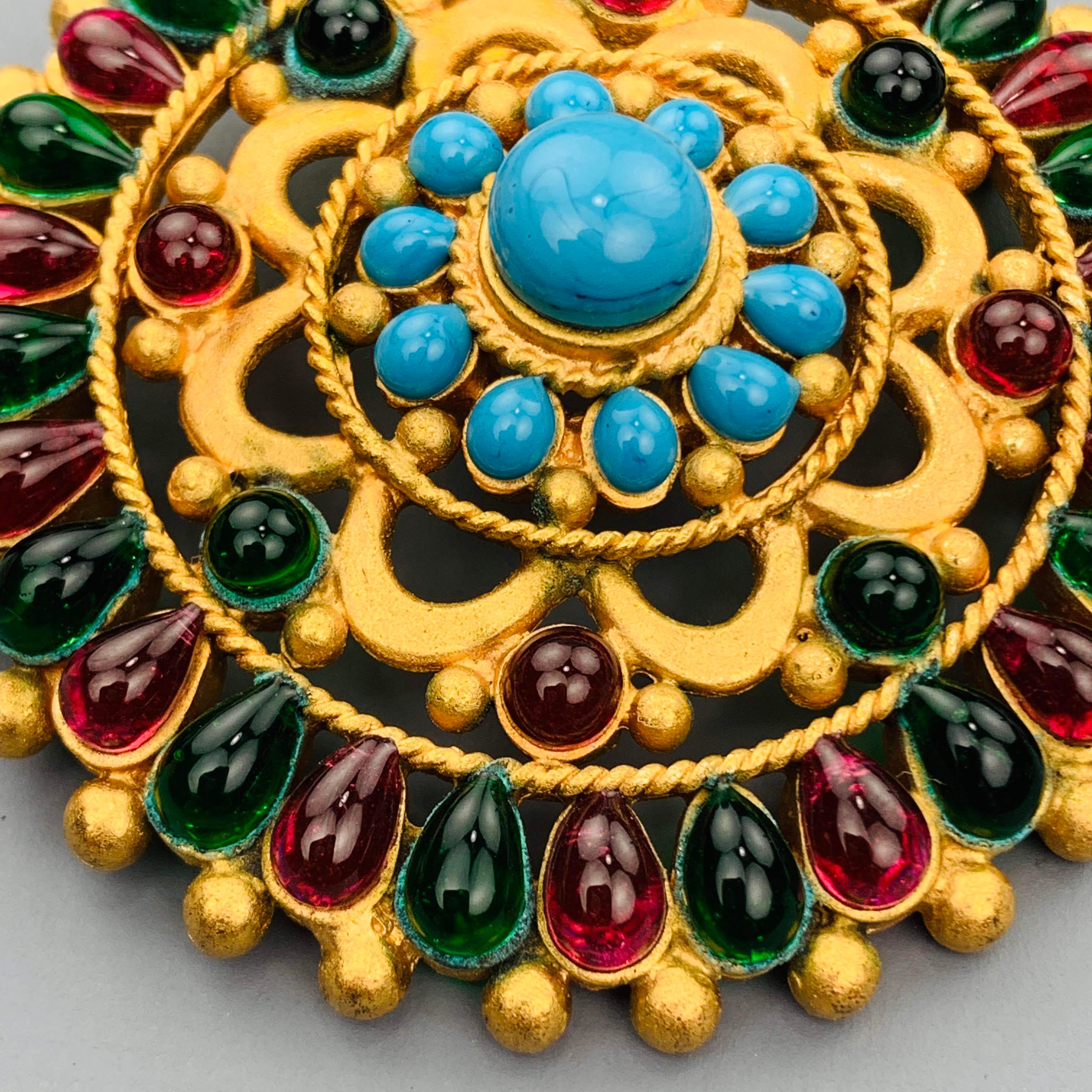 Vintage CHANEL circa 1993 Byzantine style Gripoix pin pendant comes in yellow gold tone metal with green and red glass stones and a faux turquoise center. Pin on back is missing needle bar and has a hook for a belt. As-is. Made in France.
 
Very