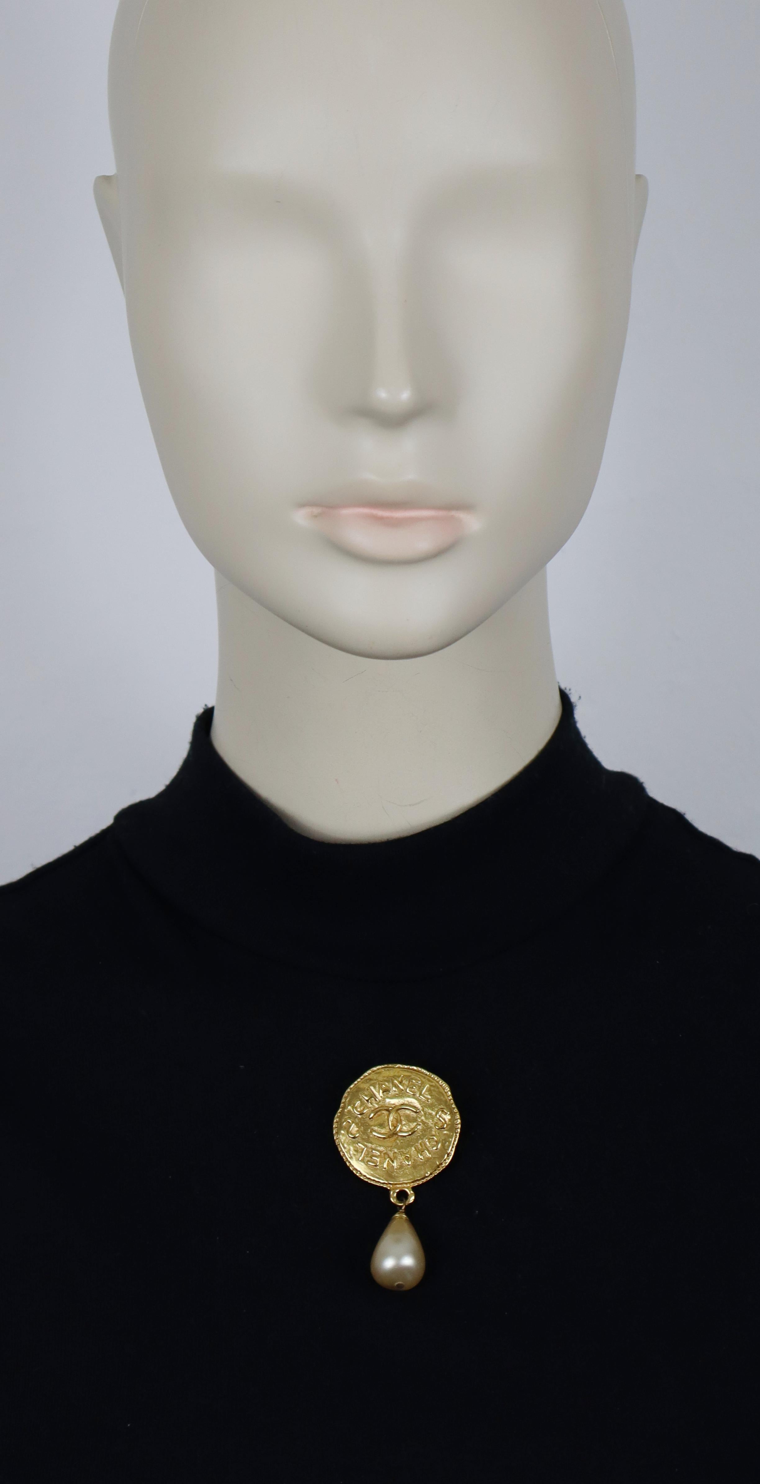 CHANEL vintage gold tone medallion CC brooch embellished with a faux pearl drop.

Embossed CHANEL 94A Made in France.

Indicative measurements : height approx. 6.2 cm (2.44 inches) / max. width approx. 3.3 cm (1.30 inches).

Material(s) : Gold tone