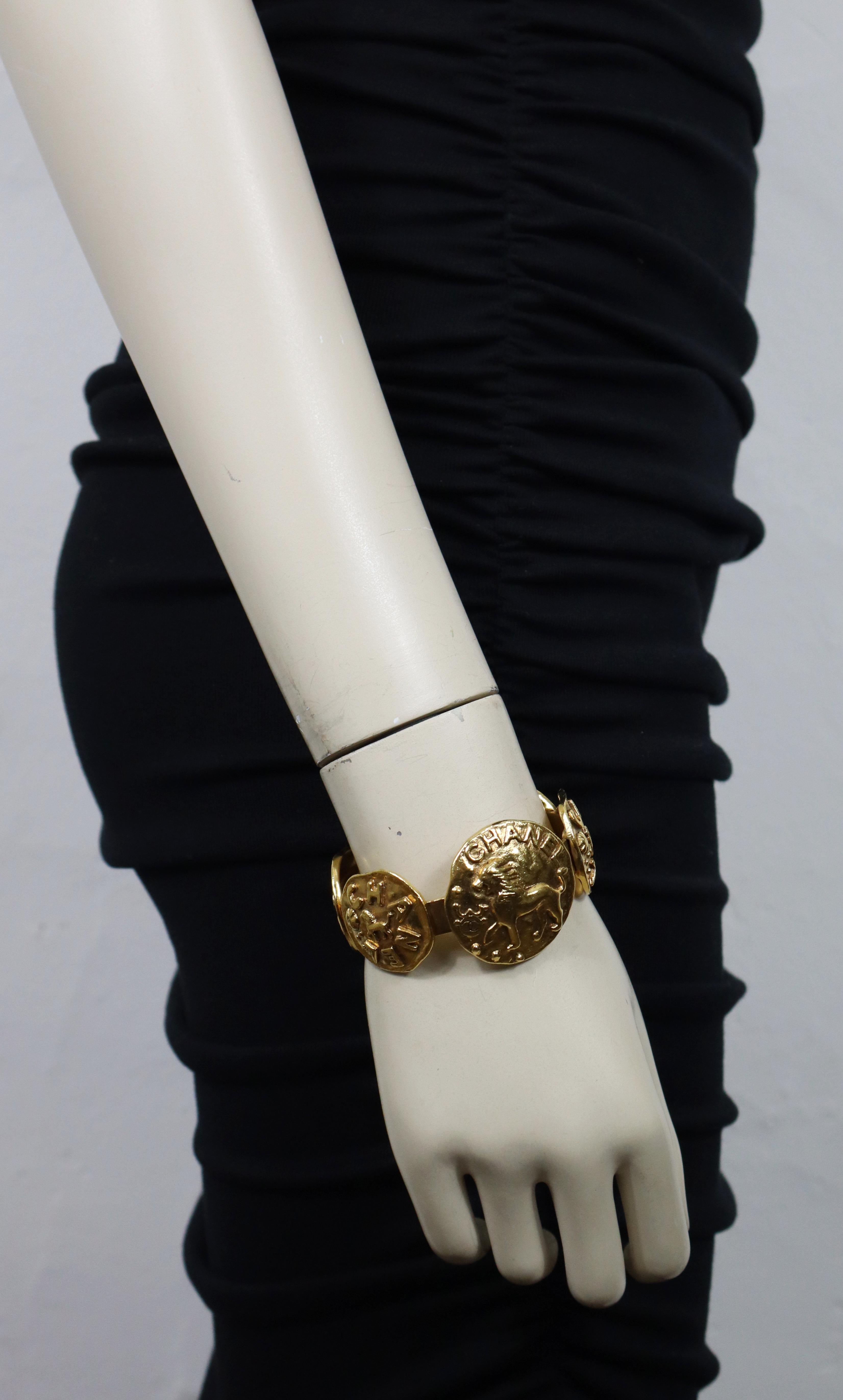 CHANEL vintage antiqued gold tone bangle bracelet featuring five medallions embossed with a lion and CHANEL logo.

Collection N°23 - Year : 1988.

Embossed CHANEL 2 3 Made in France.

Indicative measurements : inner measurements approx. 5.9 cm x 5