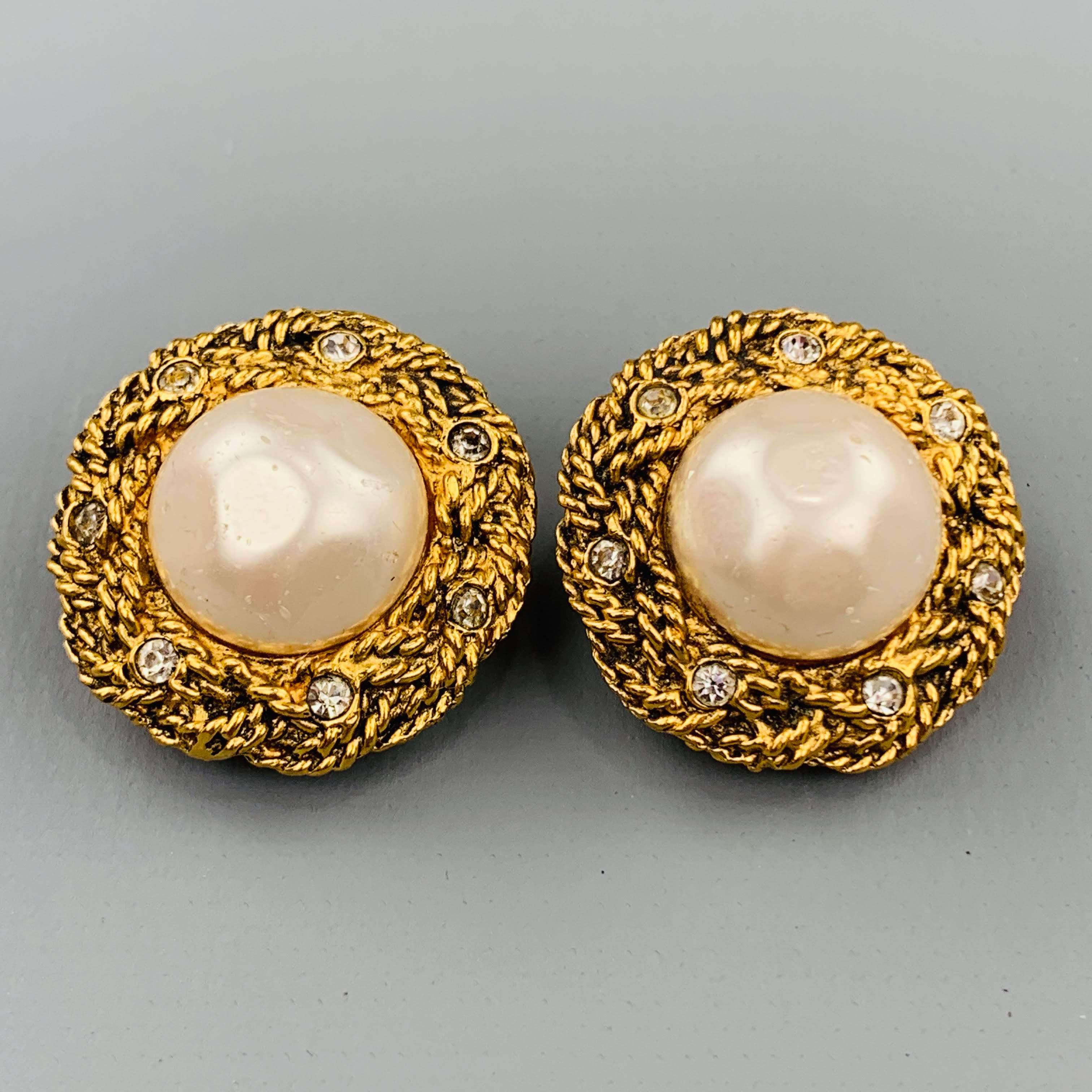 Vintage CHANEL (Circa 1971-1980) round clip on earrings come in a woven textured yellow gold tone metal with rhinestones and faux pearl center.
 
Very Good Pre-Owned Condition.
 
2.5 cm.