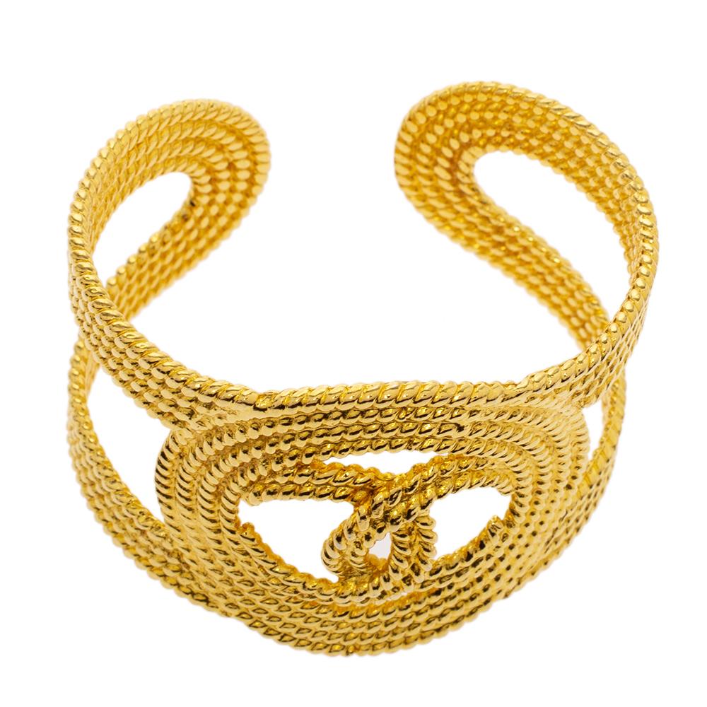 This marvelously designed cuff bracelet by Chanel is so pretty you'll love having it on your wrist. The gold-toned creation has been designed from sturdy and polished metal and has the iconic CC logo at the front center. It will make a simple and
