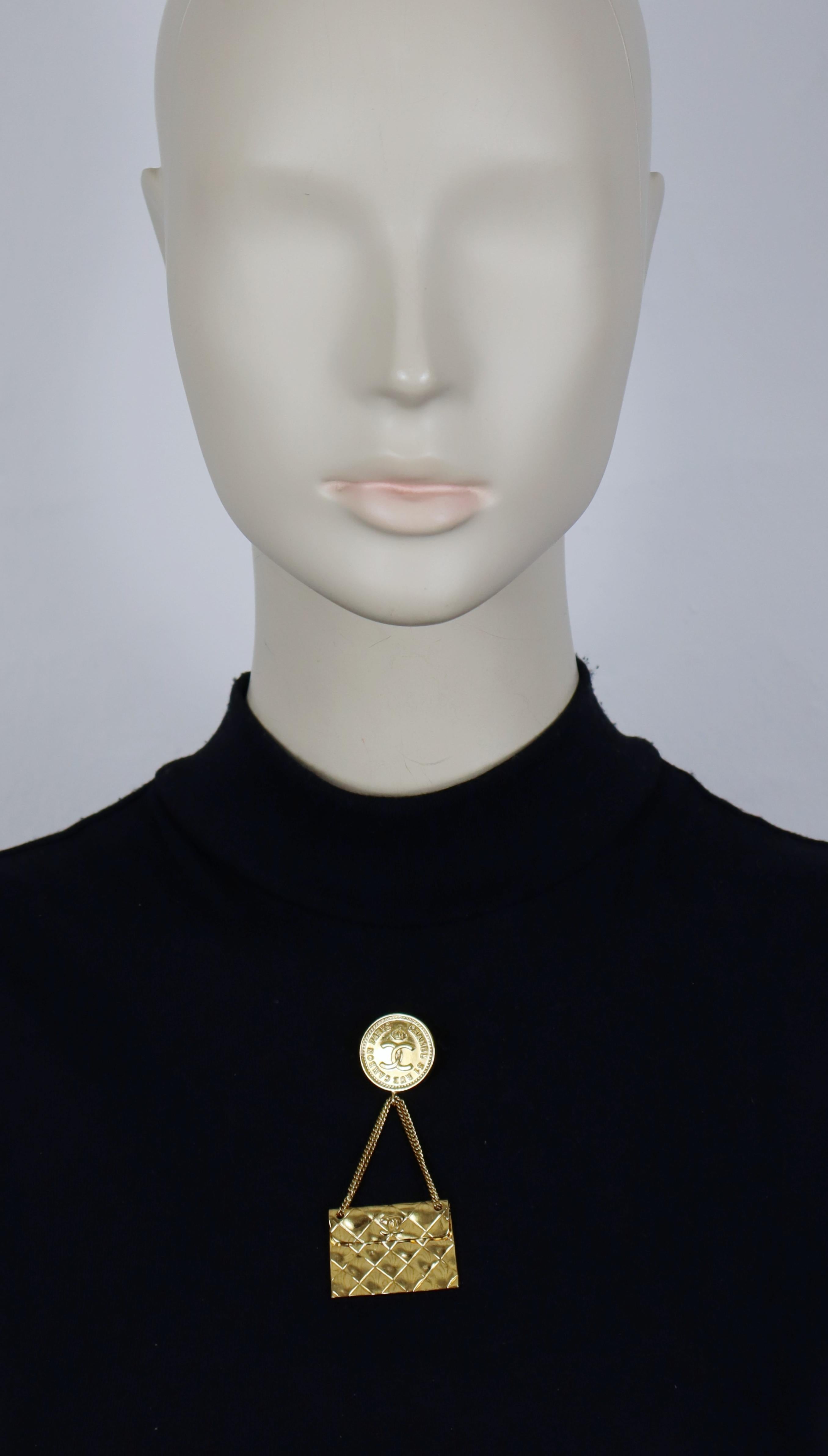 Broche colgante vintage CHANEL en tono dorado con un icónico bolso acolchado rematado por un medallón CC coronado.

Estampado CHANEL.

Medidas orientativas: altura aprox. 7,8 cm / anchura máx. aprox. 3,5 cm.

Materiales : Herrajes de metal en tono