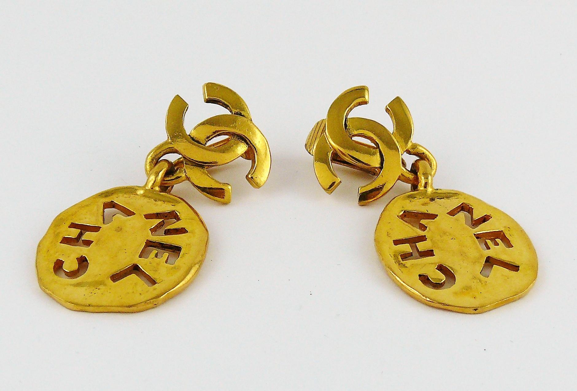 CHANEL vintage gold toned dangling earrings (clip-on) featuring a CC logo top and a cut-out CHANEL irregular coin drop.

Embossed CHANEL.

Indicative measurements : height approx. 4.8 cm (1.89 inches) / max width approx. 2.4 cm (0.94 inch).

JEWELRY