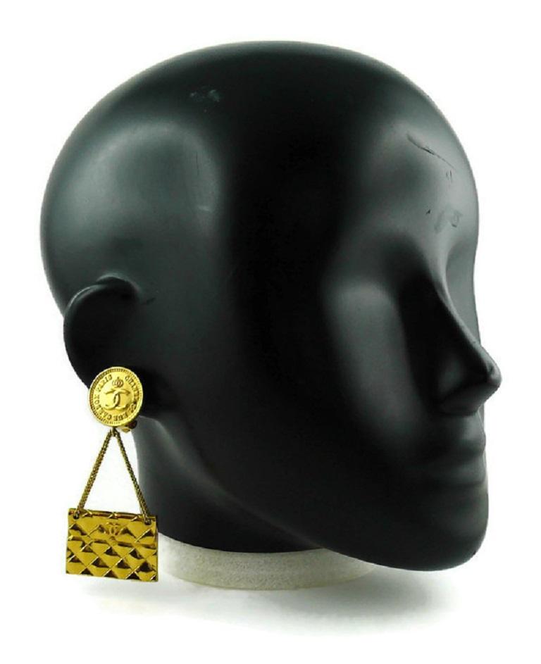 CHANEL vintage gold toned iconic dangling earrings (clip-on) featuring a crown CC coin top with a quilted flap bag charm.

Collection 23 (year : 1988).

Marked CHANEL 2 3 Made in France.

Indicative measurements : height approx. 7.7 cm (3.03 inches)