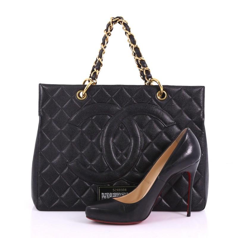 This Chanel Vintage Grand Shopping Tote Quilted Caviar, crafted from black quilted caviar leather, features woven-in leather chain straps, stitched CC logo at its center, protective base studs, and gold-tone hardware. It opens to a black leather
