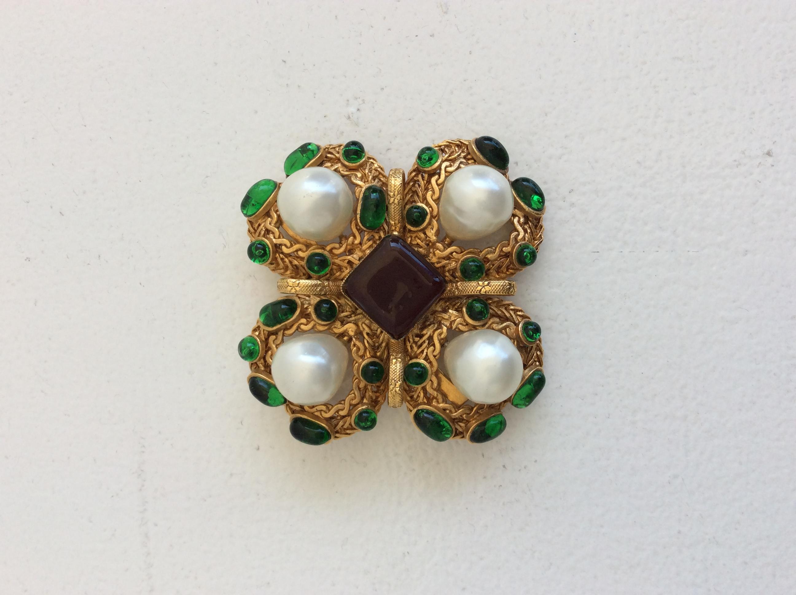 Chanel Vintage Gripoix Brooch. Textured, gold-tone, featuring 4 faux pearls and glass embellishments along with pin closure. Hook featured on the back to transform brooch into a necklace (see photo attached). 