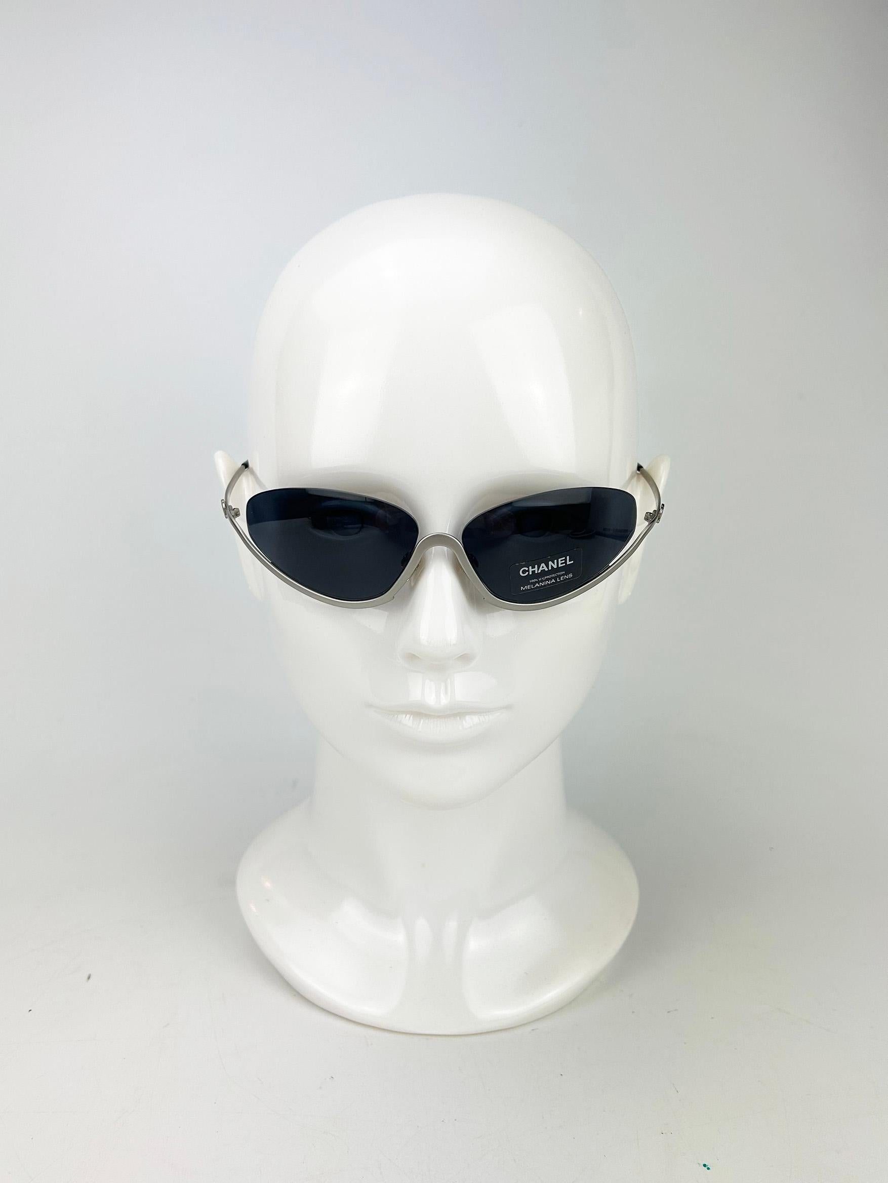 Lunettes de soleil Chanel Vintage Half Frame Floating Gray Lens Silver c2000s en excellent état. Monture en métal argenté mat au design unique de lentilles semi-flottantes sans monture autour du haut de chaque lentille. Lentilles ovales gris bleu