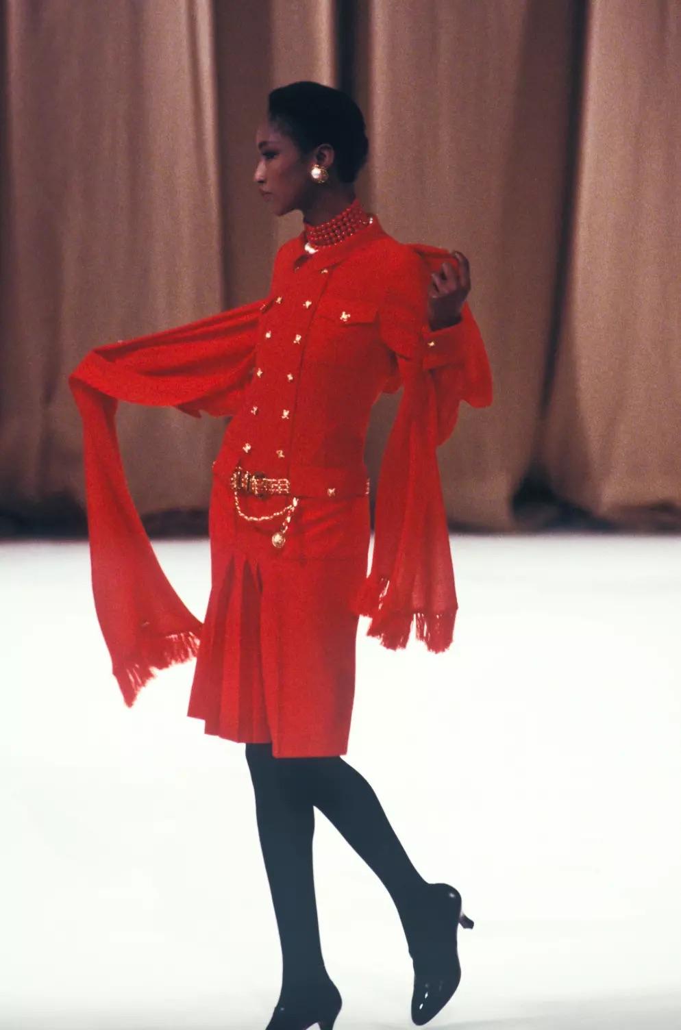 Werfen Sie einen Blick auf dieses besondere Haute Couture-Kleid aus der Herbst/Winter-Kollektion 1988 von Chanel von Karl Lagerfeld. Dieses zeitlose Kleid in Pariser Rot ist mit goldenen Matelassé-Rautenknöpfen verziert, die mit Lederakzenten