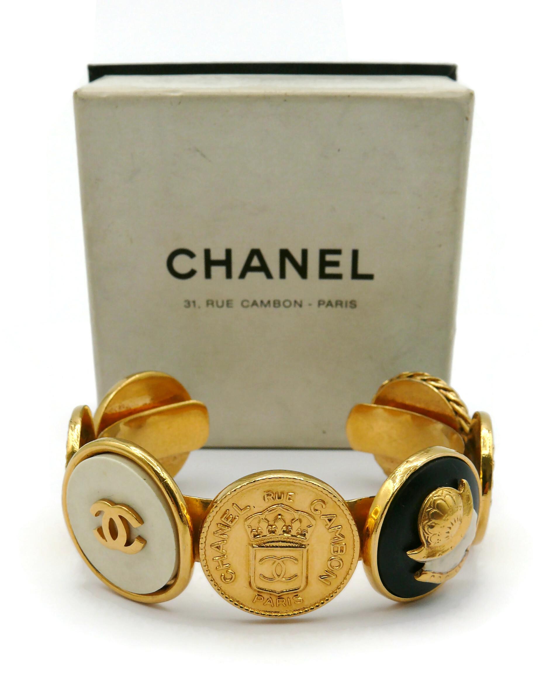 CHANEL vintage iconic gold tone bangle bracelet featuring coins : Crowned CC CHANEL 31 Rue Cambon Paris, Elephant, Helmeted Guards, CC logos and a Lady profile.

Embossed CHANEL.

Indicative measurements : inner measurements approx. 5.9 cm x 4.6 cm