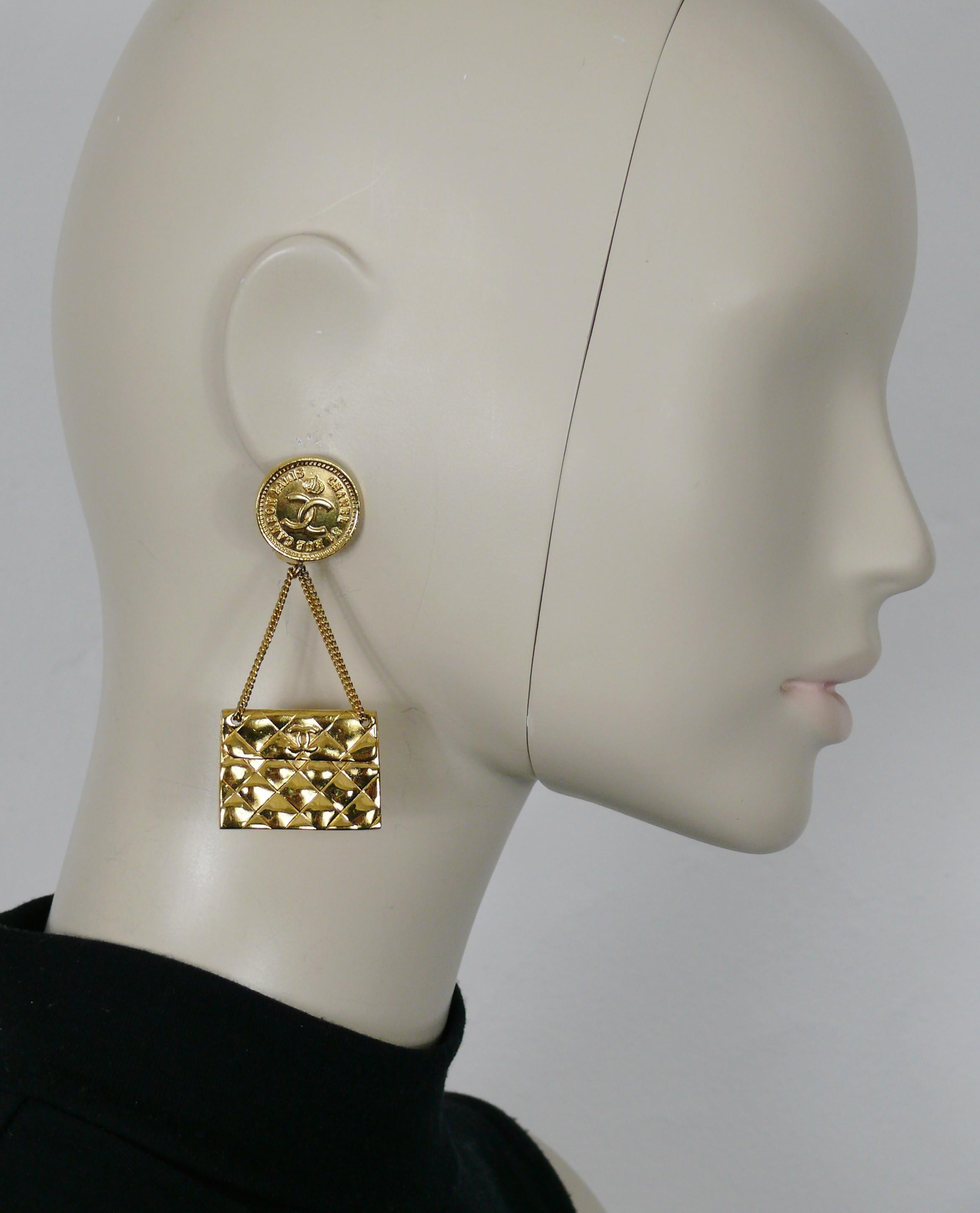 CHANEL vintage gold tone iconic dangling earrings (clip-on) featuring quilted flab bag topped by a crowned CC logo coin.

Embossed CHANEL.

Indicative measurements : height approx. 7.6 cm (2.99 inches) / max. width approx. 3.3 cm (1.30