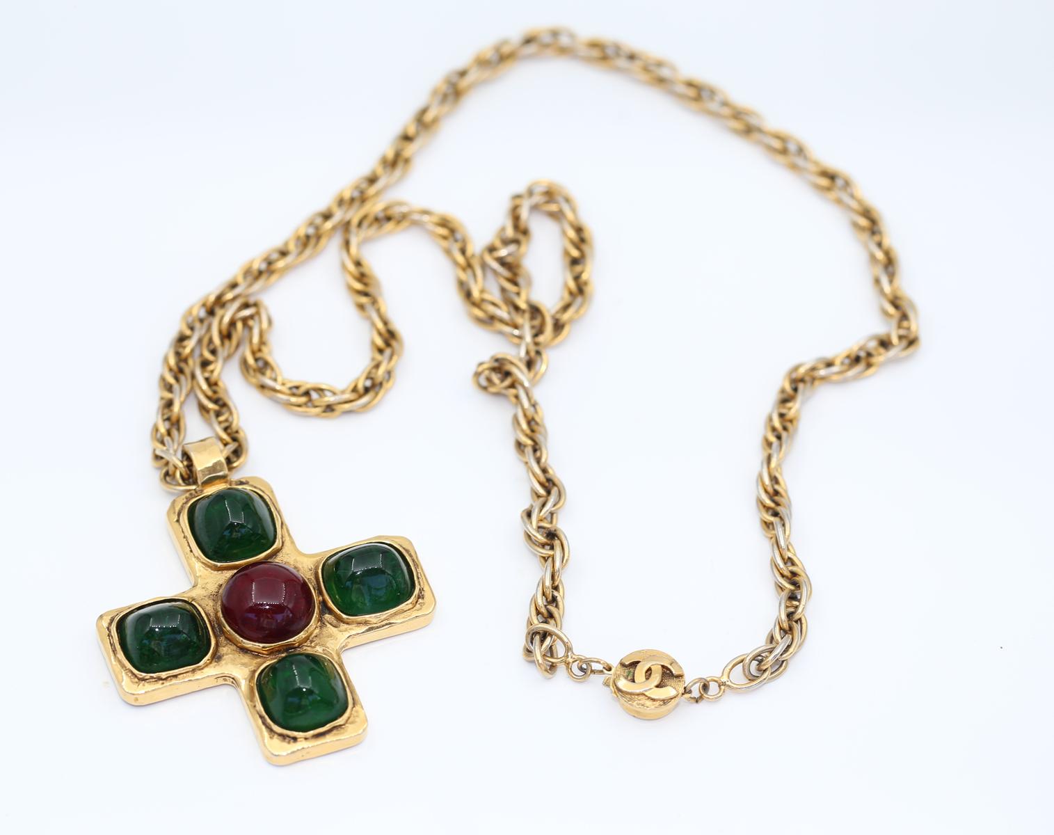 Vintage 1970es CHANEL Gripoix Iconic Cross Pendant.
The items is truly massive with Chanel Cross Red and Green Gripoix Glass cabochons. The chain is really long and has a Chanel sign on the lock. It is a real fashion statement that is hard to deny.