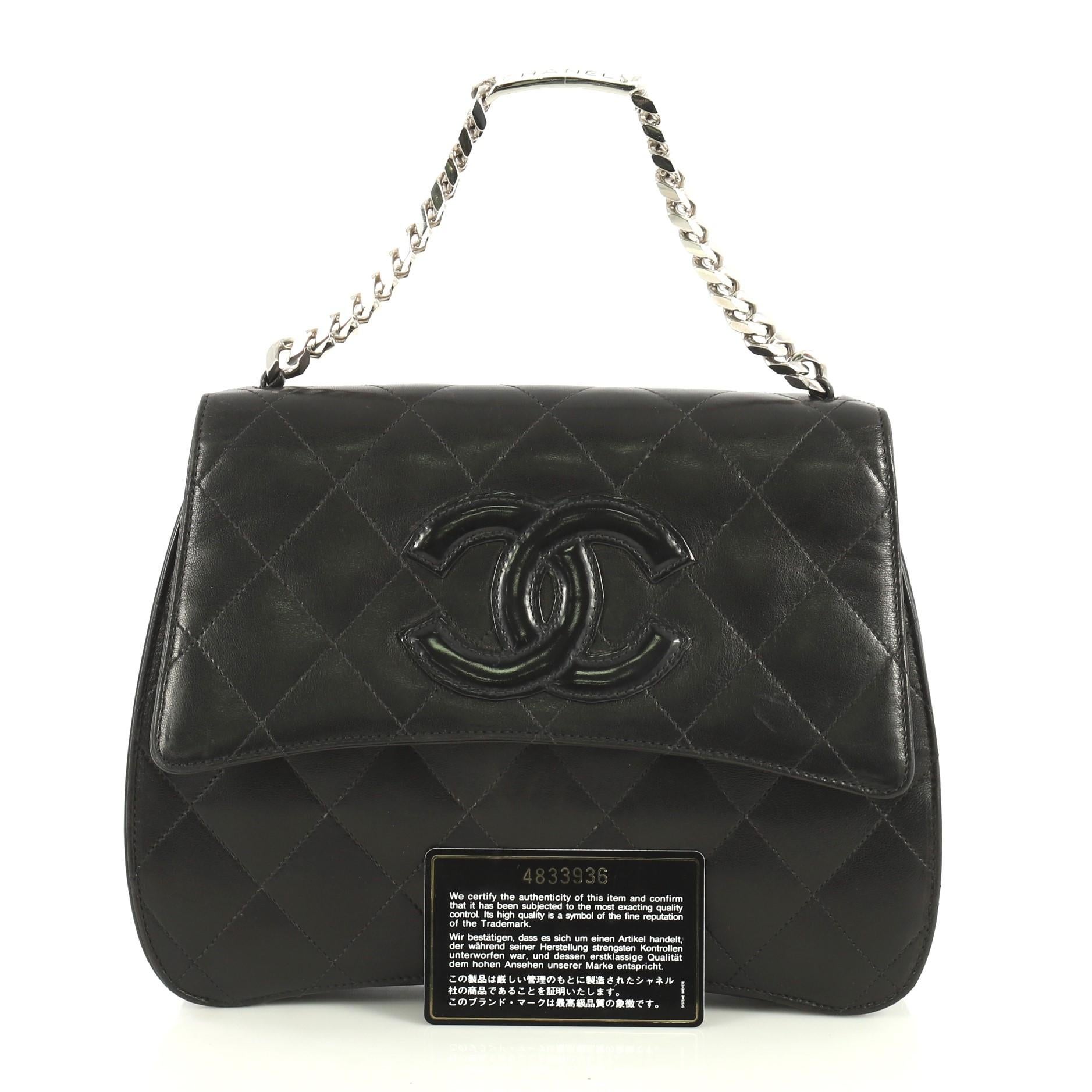 This Chanel Vintage ID Bracelet Bag Quilted Lambskin Medium, crafted from black quilted lambskin leather, features chain link handle and silver-tone hardware. Its flap with snap closure opens to a red leather interior with zip and slip pockets.