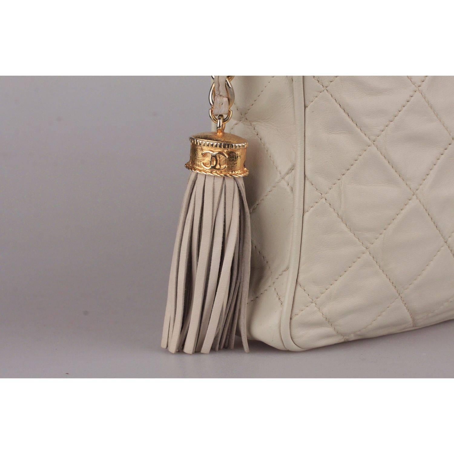 - Vintage Chanel Classic Camera bag with CC - CHANEL logo front stitching 
- Period/Era: 1986 to 1988
- Ivory quilted lambskin leather 
-  Upper zip closure
- Chanel chain 
- Tassel zipper pull 
- Lined in leather 
-  'CHANEL' embossed inside, 'Made