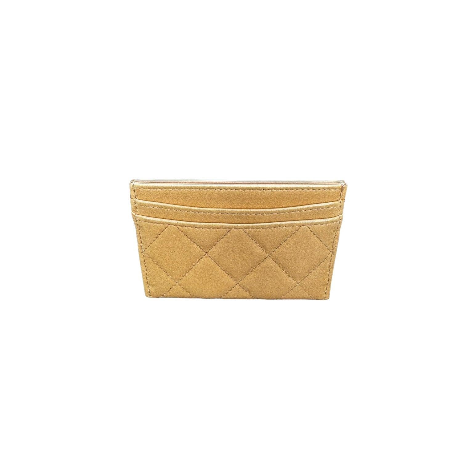 This Chanel card holder is crafted of quilted lambskin leather in dark beige with a silver frontal Chanel CC logo at front face. The exterior features three card slots with beige fabric interiors and a main compartment in the center.

Designer: