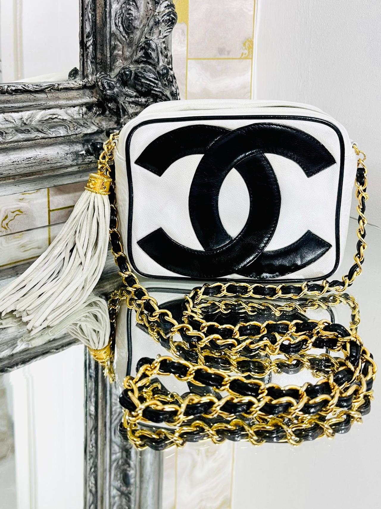 Very Rare - Chanel Vintage Leather Double 'CC' Logo Camera Bag

White quilted leather, crossbody bag with large black 'CC' logo

to both sides. 24k Gold plated hardware. Logo cap tassel to one side

and iconic chain and contrasting black leather