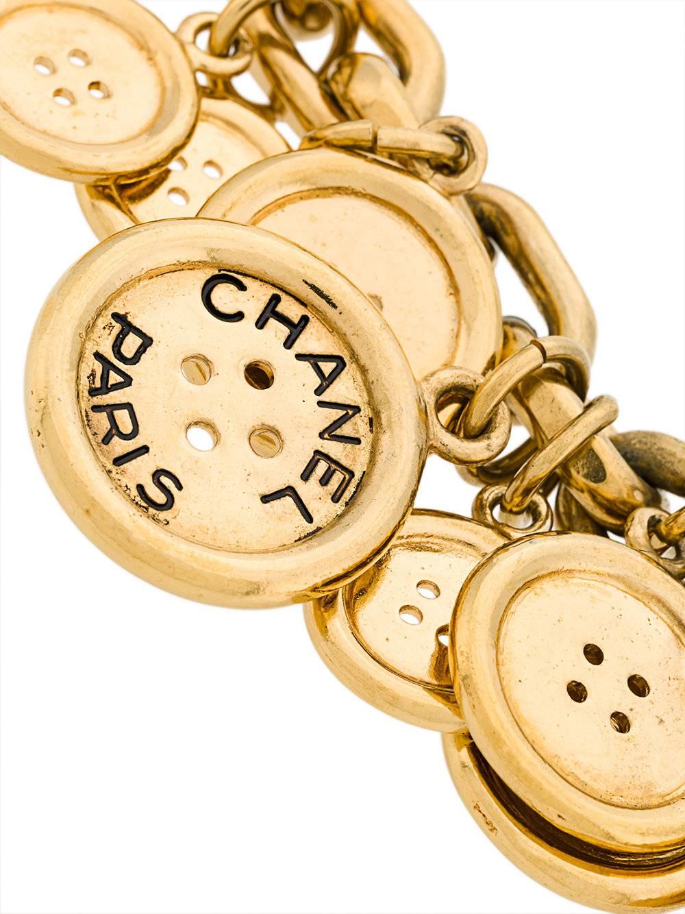 Gold-toned button charm bracelet featuring a T-bar fastening and a chunky chain.

Colour: Pale Gold

Material: gold- plated metal

Measurements: One Size

Condition: Excellent
