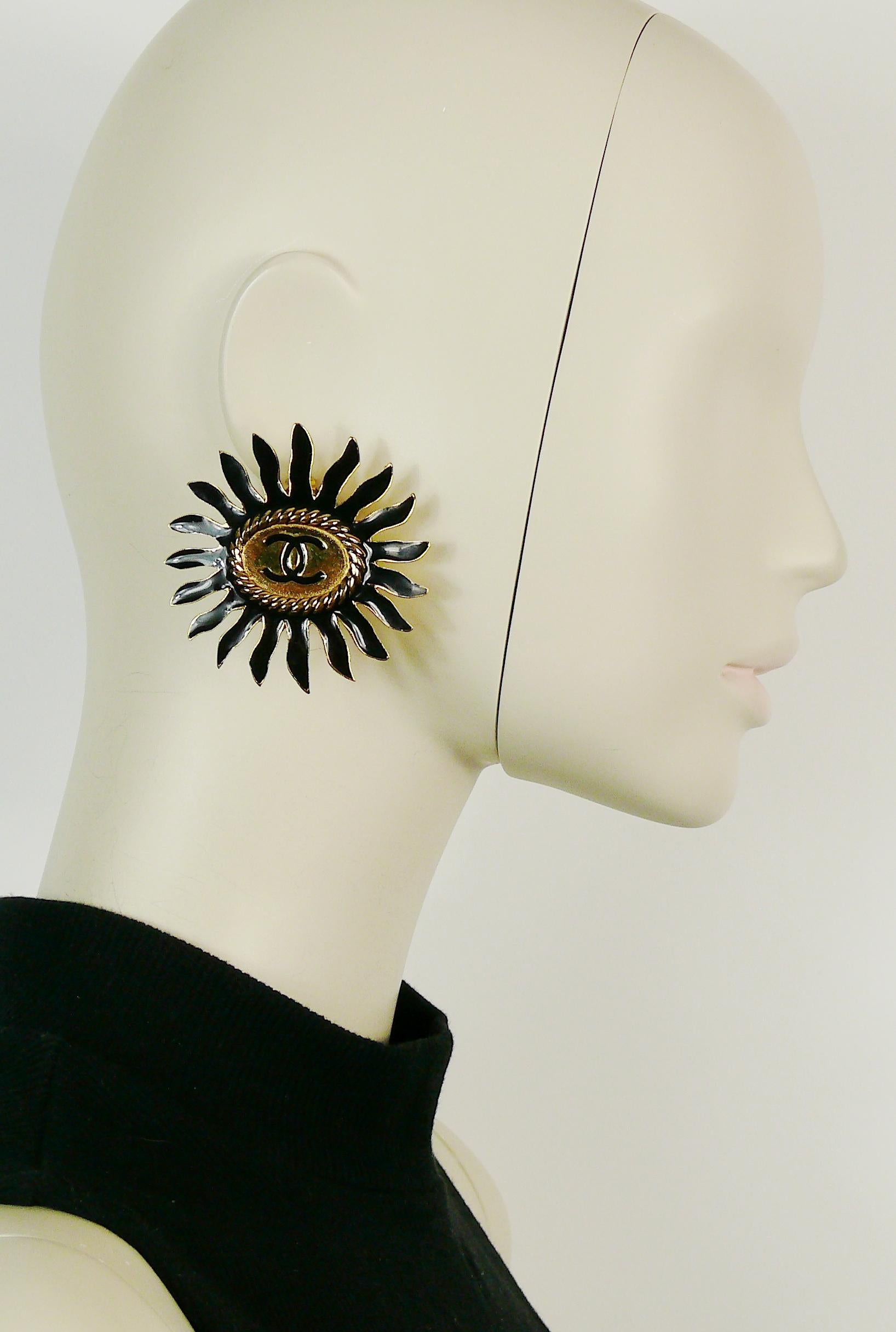 CHANEL vintage rare massive gold toned and black enamel sunburst clip-on earrings featuring CC monogram.

Embossed CHANEL.

Indicative measurements : width approx. 5.8 cm (2.28 inches) / height approx. 5.8 cm (2.28 inches).
 
Comes with original box