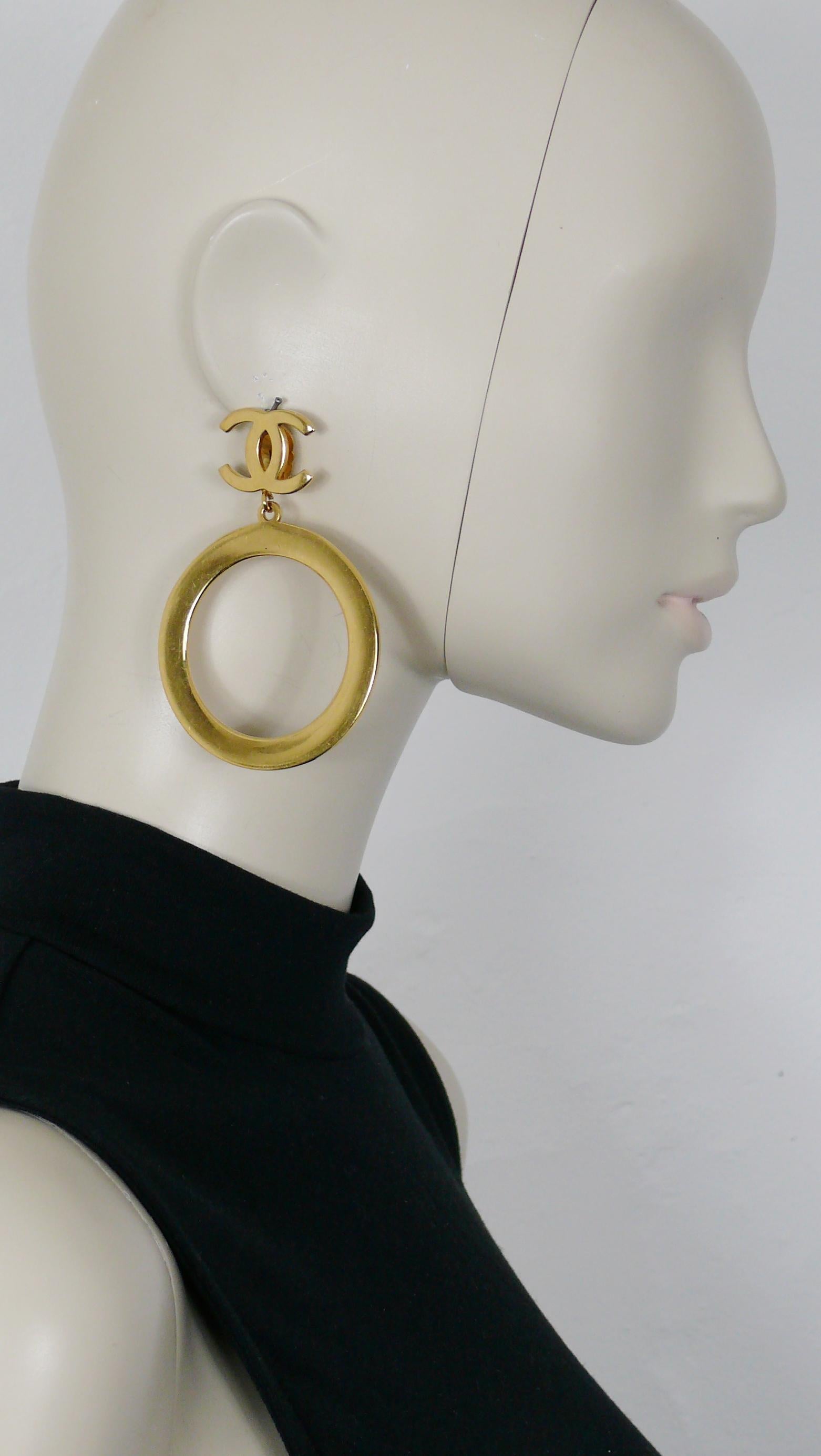 CHANEL vintage massive and iconic gold toned hoop dangling earrings (clip-on) featuring a CC logo on top.

Embossed CHANEL.

Indicative measurements : height approx. 8.6 cm (3.39 inches) / hoop diameter approx. 6 cm (2.36 inches).

NOTES
- This is a