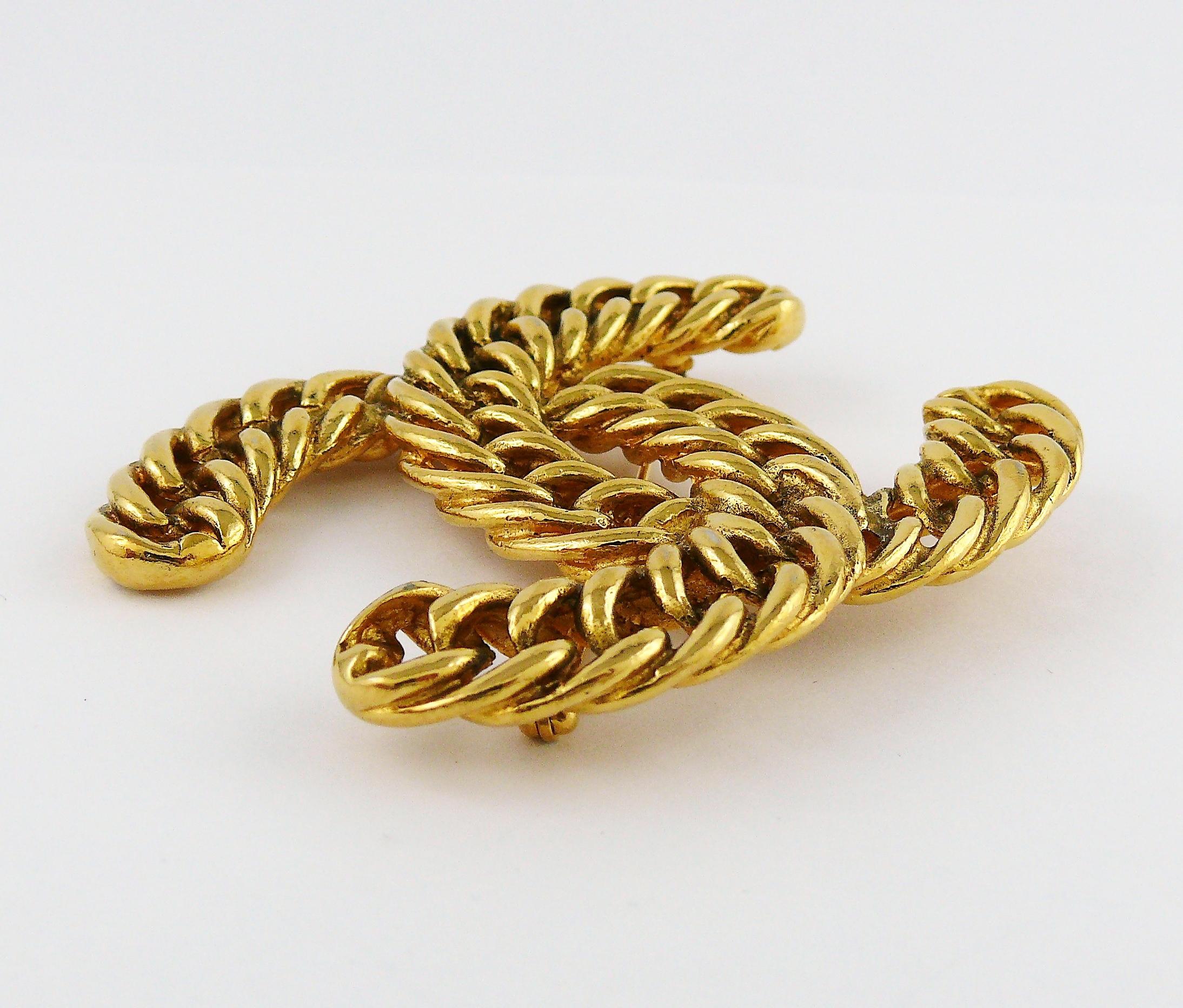 CHANEL vintage massive iconic gold toned rigid curb chain brooch featuring intertwined CC monogram.

Circa 1980.

Embossed 1107.
Unsigned (usual for this model).

Indicative measurements : height approx. 5.2 cm (2.05 inches) / width approx. 6.6 cm
