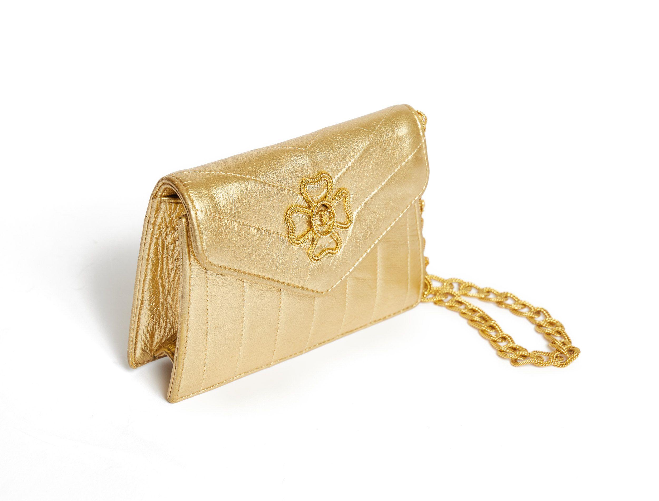 Chanel Vintage gold mini wrist bag with a golden chain made like a super elegant bracelet. The chain is decorated with little CC logos and looks like a small rope (18' long). The bag is completely golden and the perfect evening bag. On front of the