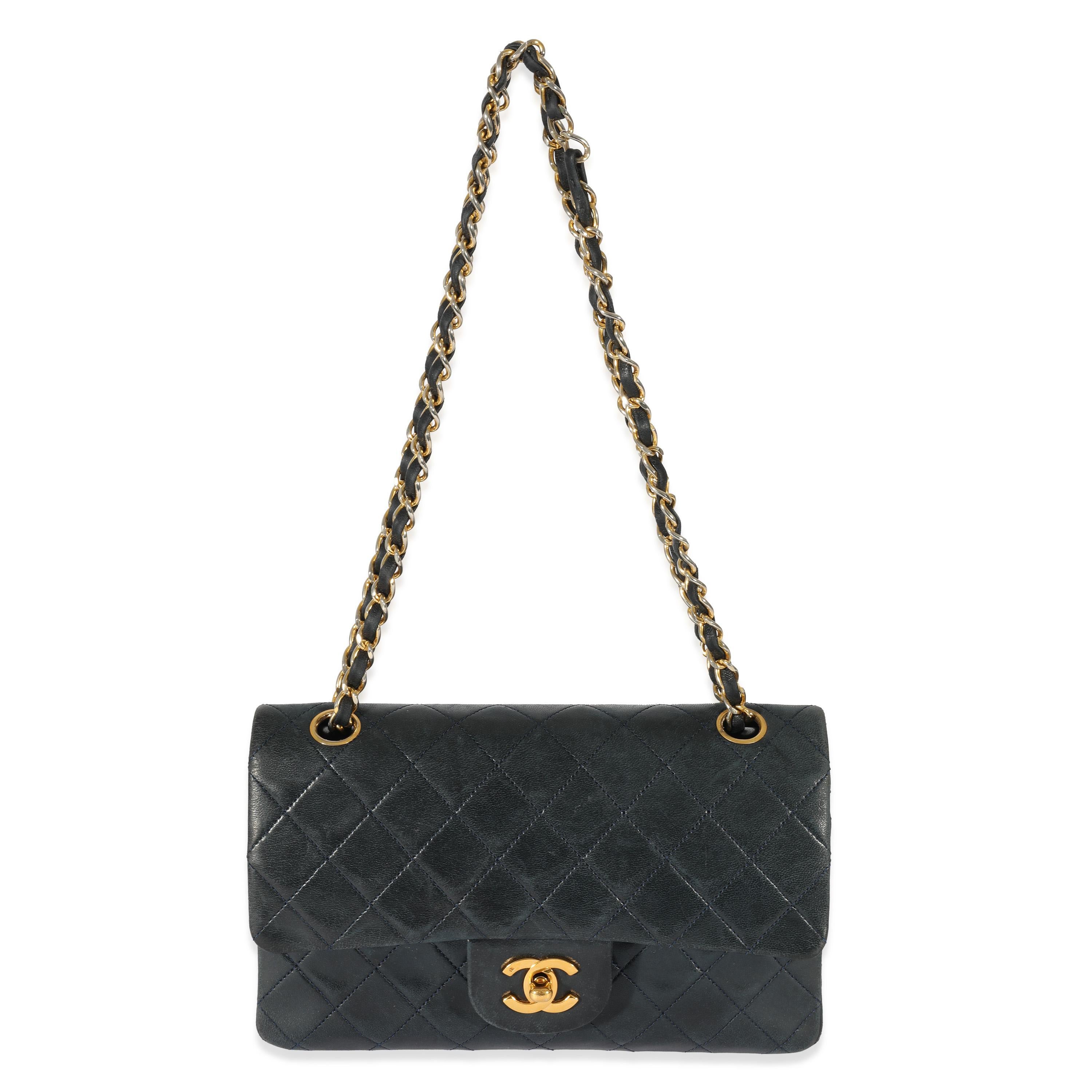 Listing Title: Chanel Vintage Navy Lambskin Small Classic Flap
SKU: 129919
Condition: Pre-owned 
Handbag Condition: Good
Condition Comments: Good Condition. Heavy exterior discoloration, scuffing, indentation, and marks. Heavy scratching and