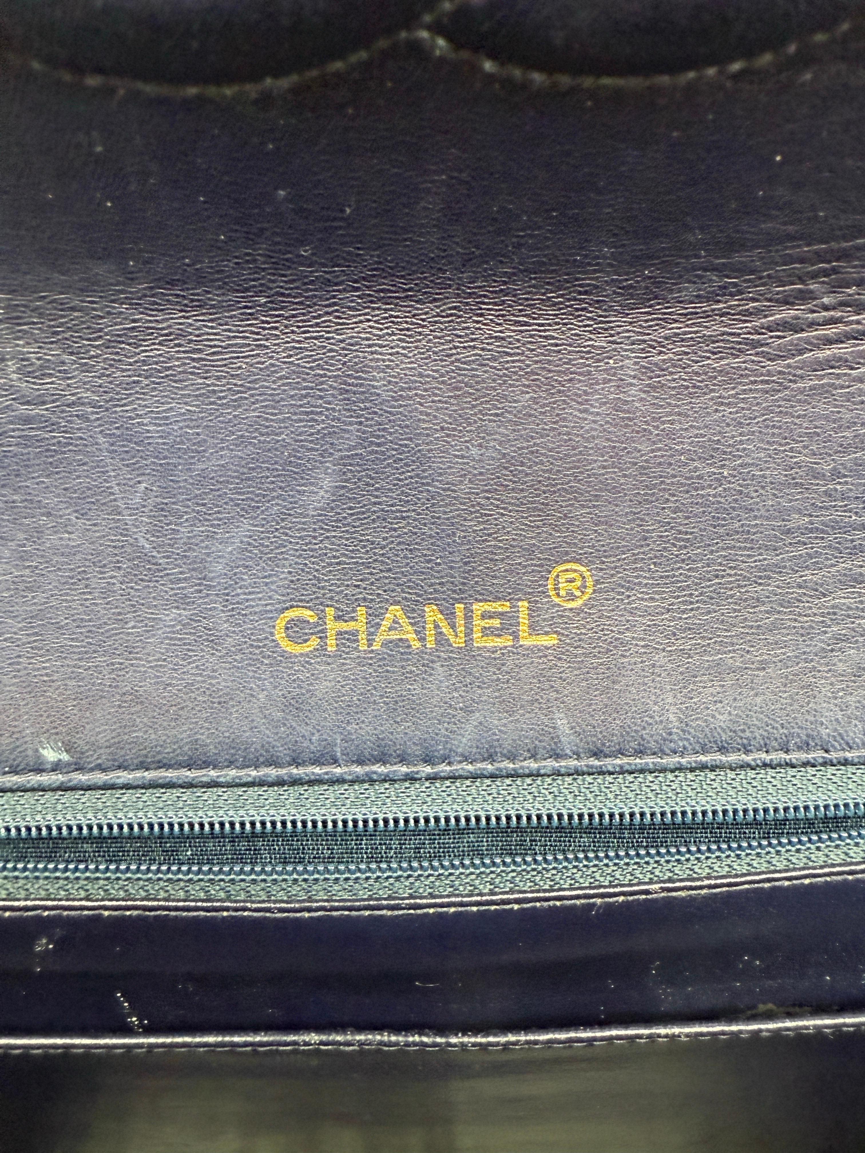 Dies ist eine begehrte Chanel Classic Maxi Flap aus der Serie 1 (1989-1991), gefertigt aus butterweichem marineblauem Lammleder und mit 24-karätig vergoldeten Beschlägen versehen. 

Mit den Maßen von ca. 34 cm × 23 cm × 10 cm (13,4″ × 9,1″ × 3,9″)