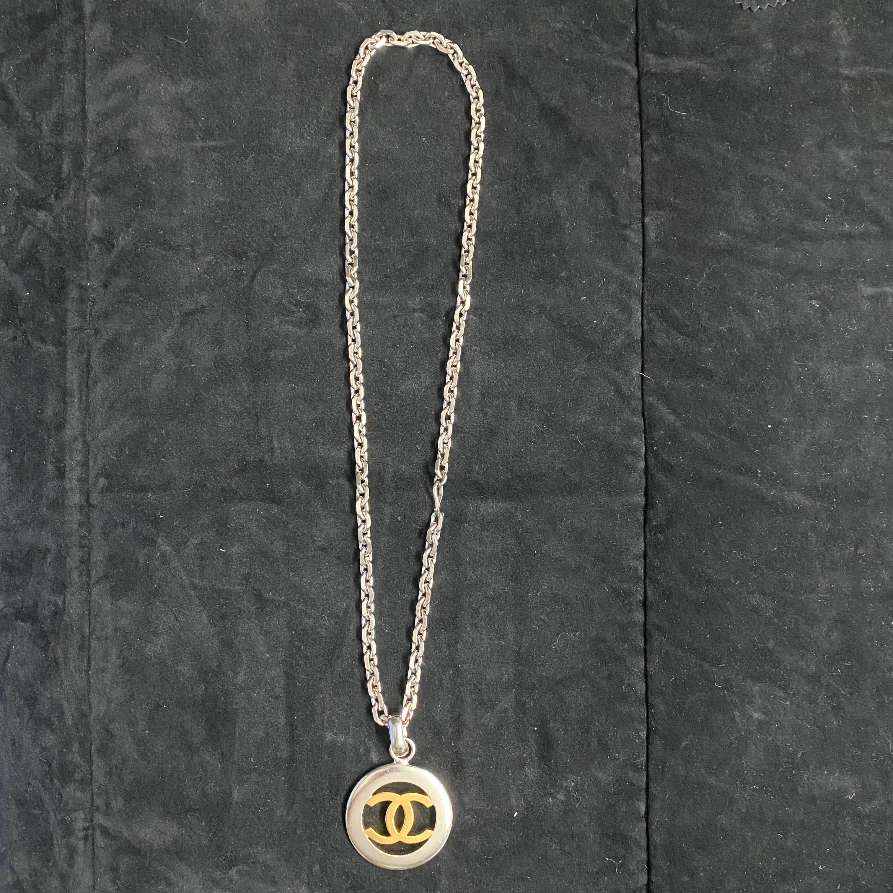 Chanel Vintage Necklace with CC pendant in gold metal, with silver neck chain and a lobster clasp closure. In good condition.