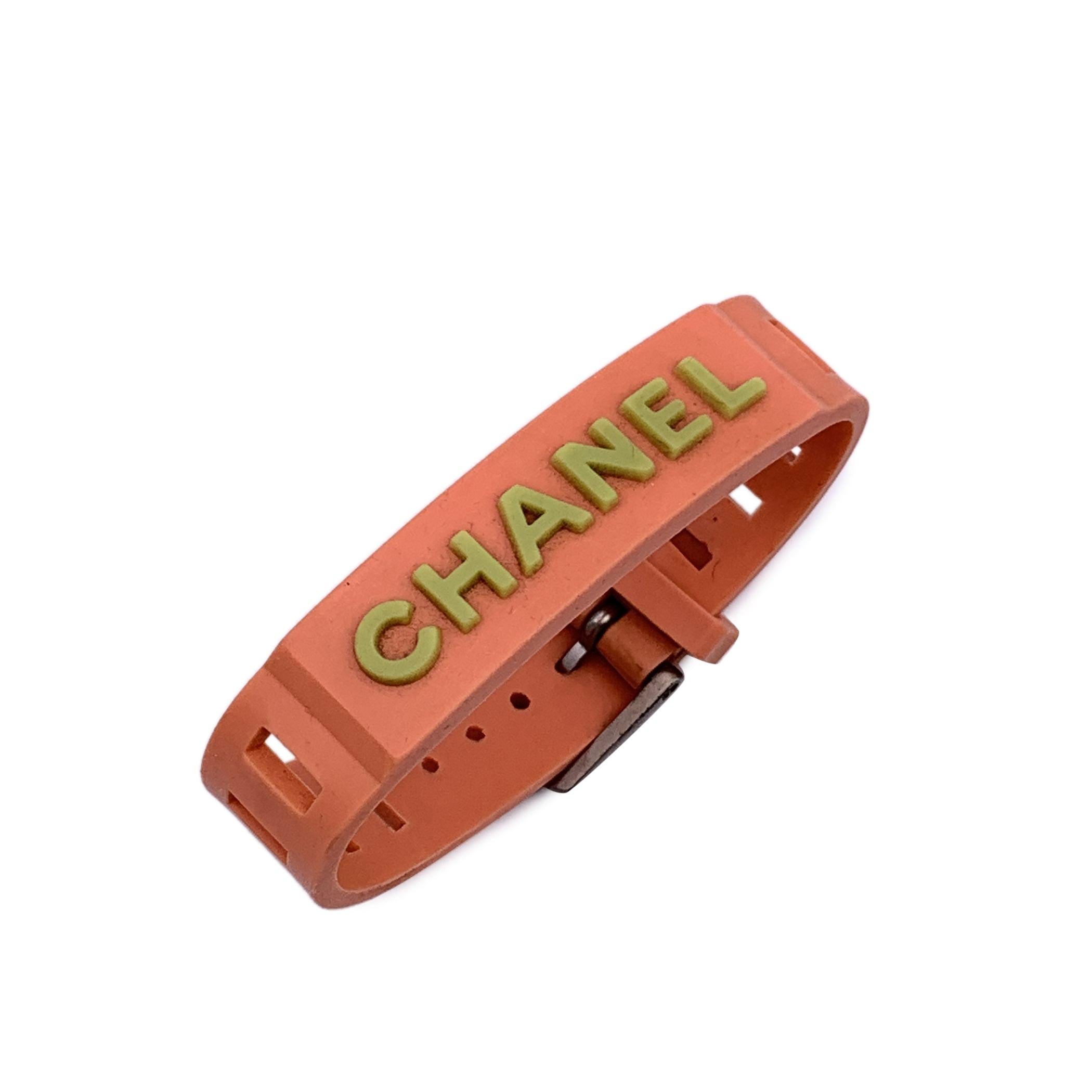 Lovely bracelet by CHANEL, crafted of orange rubber. It features pale green CHANEL writing. Buckle closure. 'Chanel 99 CC P Made in France' oval hallmark near the closure. Total lenght: 8.25 inches - 21 cm . Condition B - VERY GOOD Minimal wear of