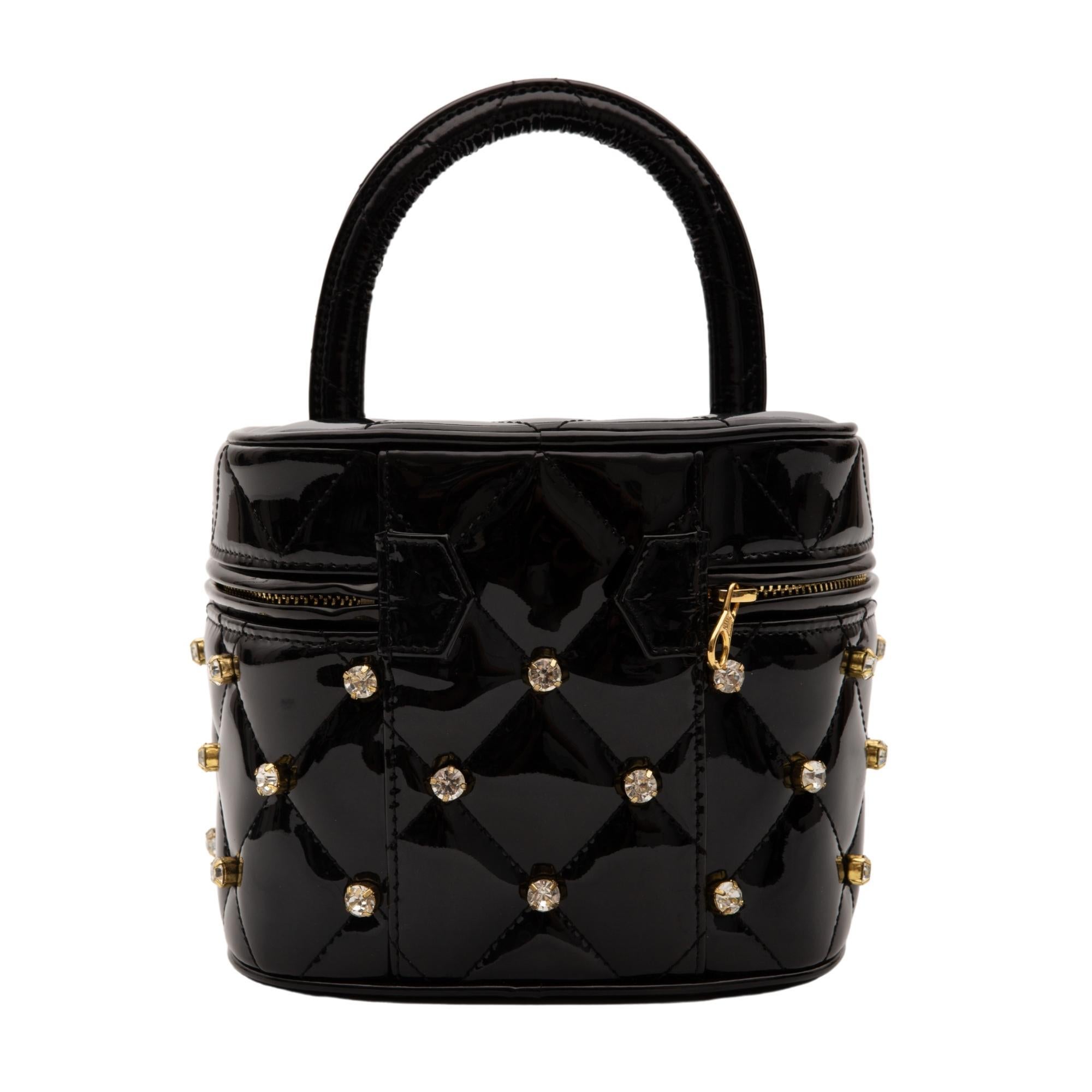 This bag is made with black patent leather and features diamond quilting, crystal embellishments, signature interlocking CC turn-lock fastening, gold-tone hardware, single rolled leather top handle, all-around zip fastening, main compartment,