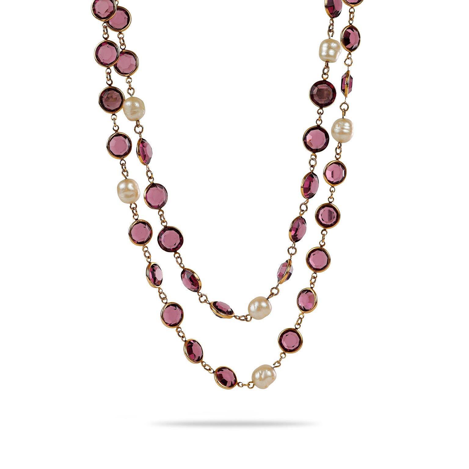 This authentic Chanel Pearl and Purple Crystal Satoir Necklace is in excellent vintage condition from the 1981 collection.  Rose cut purple crystals and faux pearls are situated on an extra long gold tone chain.  Pouch or box included.

PBF 13194 