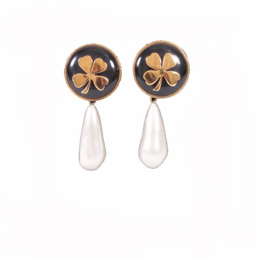 Vintage Chanel clip-on earrings from the 80's in gilt metal, dangling with the inevitable four-leaf clovers.

Pearly molten glass beads (small marks of use). In very good condition.

Dimensions: height: 7 cm, width of the upper loops: 3 cm.

Will be
