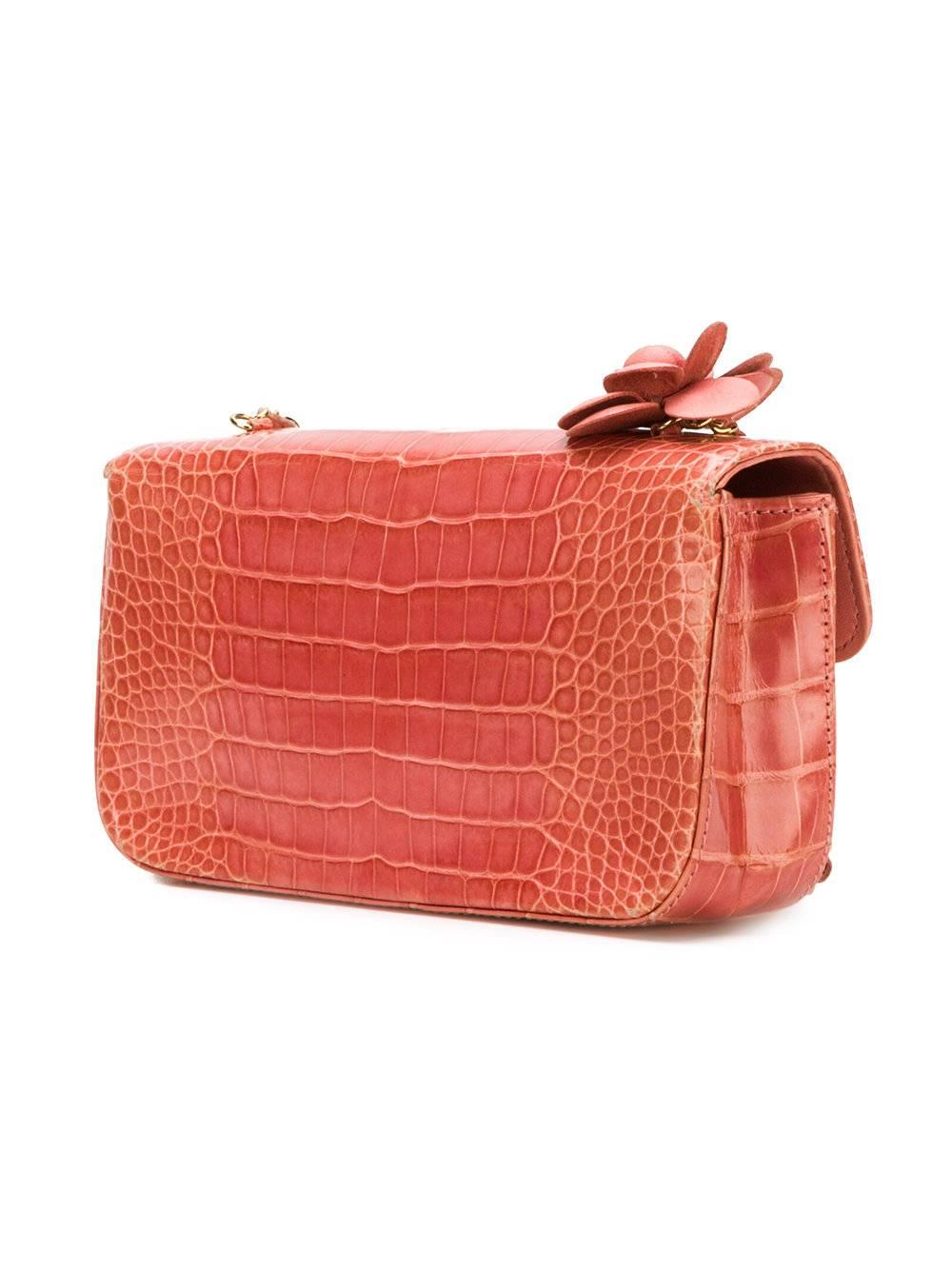 Pink calf leather rosette shoulder bag featuring a foldover top with magnetic closure, a main internal compartment and a chain link strap. 

Colour: Pink

Composition: Crocodile leather

One Size

Condition: 8/10
