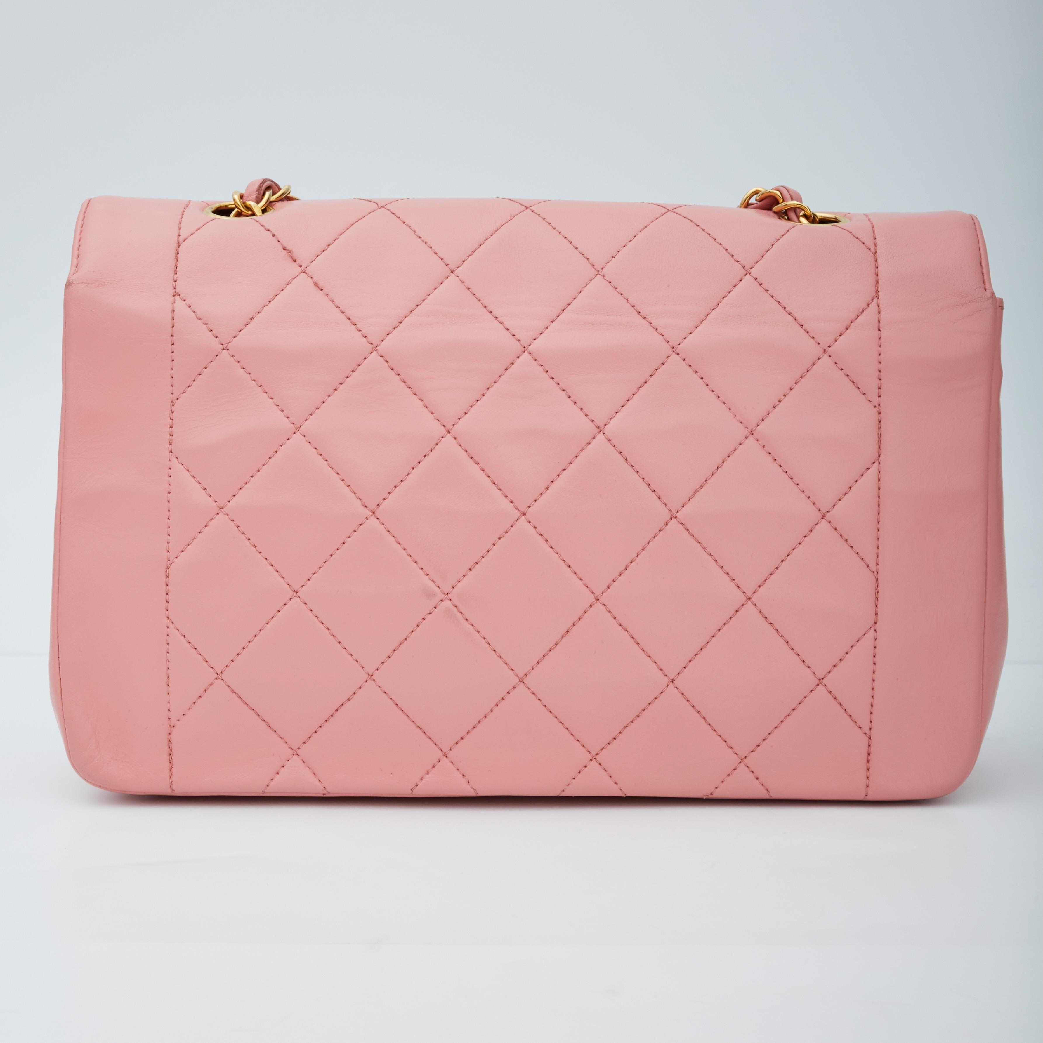 This classic model nicknamed the Diana is constructed of supple diamond-quilted lambskin leather in pink. The shoulder bag features a waist-length polished gold chain-link and leather shoulder strap, Chanel CC turn lock closure on front flap and a