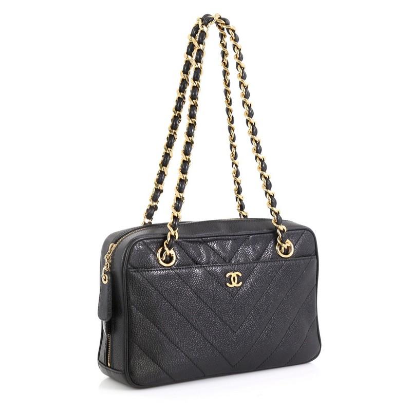 This Chanel Vintage Pocket Camera Bag Chevron Caviar Small, crafted from black chevron caviar leather, features woven-in leather chain strap, exterior front slip pocket, and gold-tone hardware. Its zip closure opens to a black fabric interior with