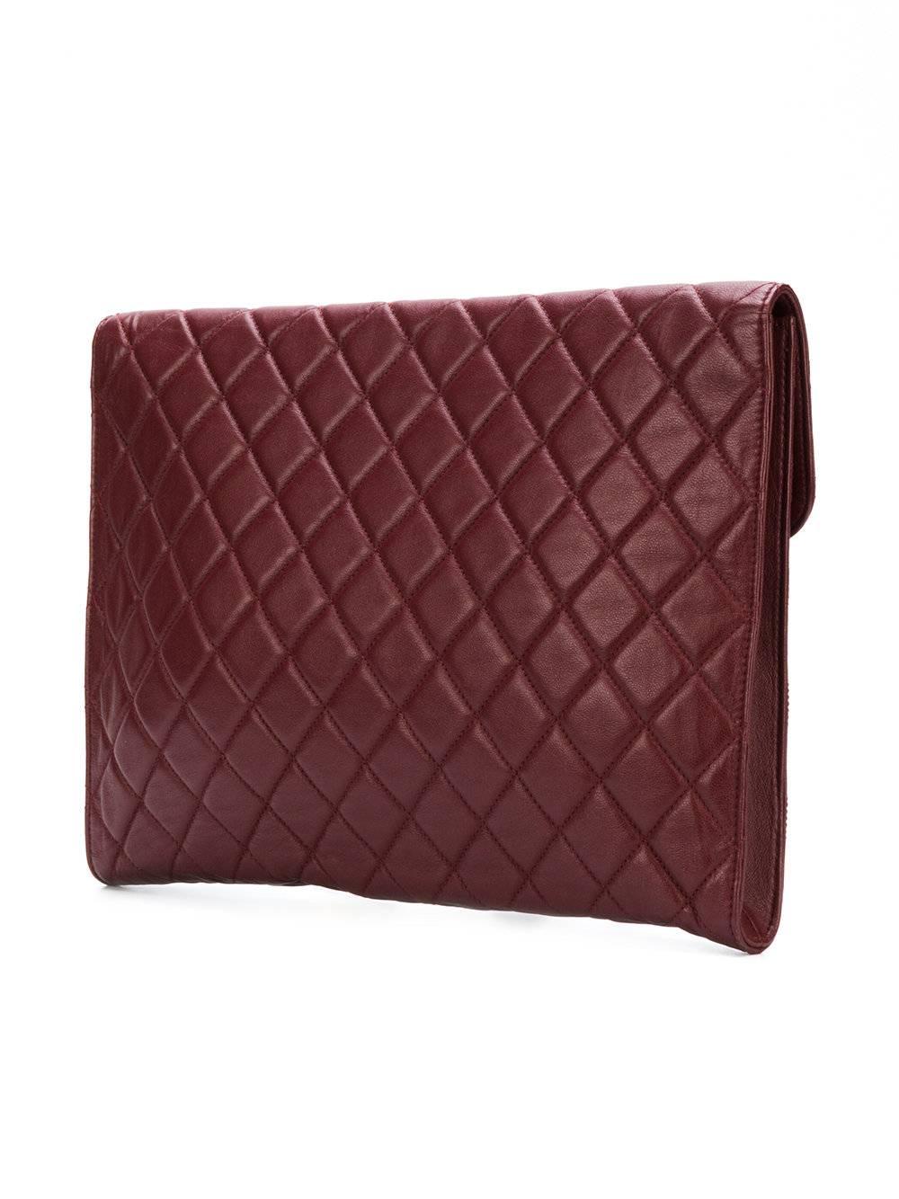 Burgundy lambskin CC oversized clutch featuring a foldover top with snap closure, a main internal compartment and a diamond quilted finish.

Colour: Burgundy

Composition: Lambskin

Measurements: W: 34cm, H: 26cm, D: 3cm

Condition: 9/10