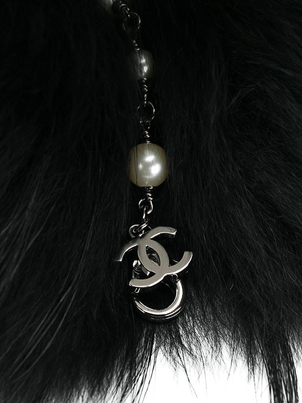 Black cashmere raccoon fur collar from Chanel e featuring a cc faux-pearl chain. 

Colour: Black

Composition: 100% Cashmere (Lining), 100% Racoon Fur (Outer)

One Size

Condition: 10/10