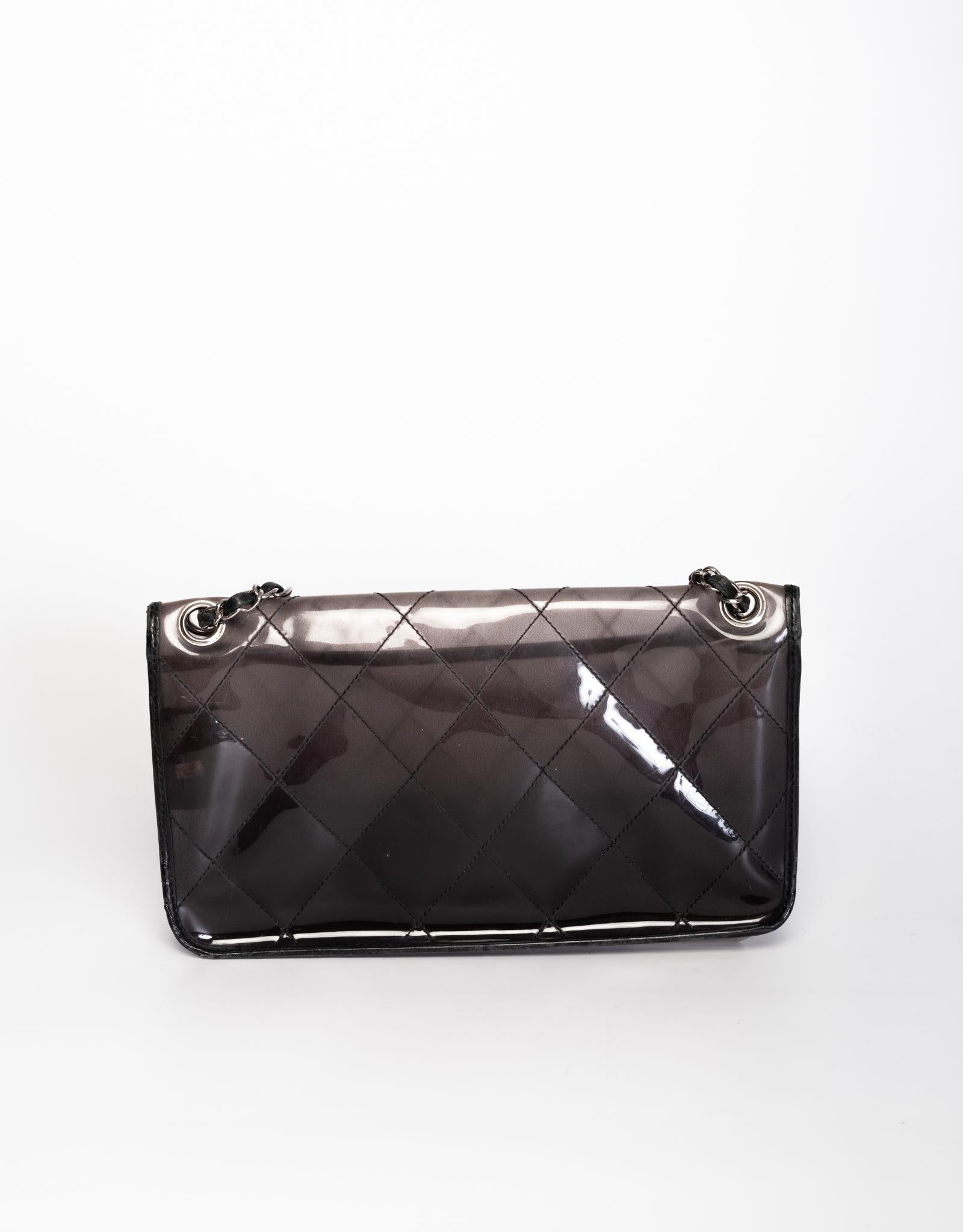 This unique Chanel classic flap bag is made of vinyl with a smokey black ombre (gradient) color with signature diamond quilted stitching. Featuring sliver tone hardware, a front flap with the signature interlocking CC turn lock closure, a sliver