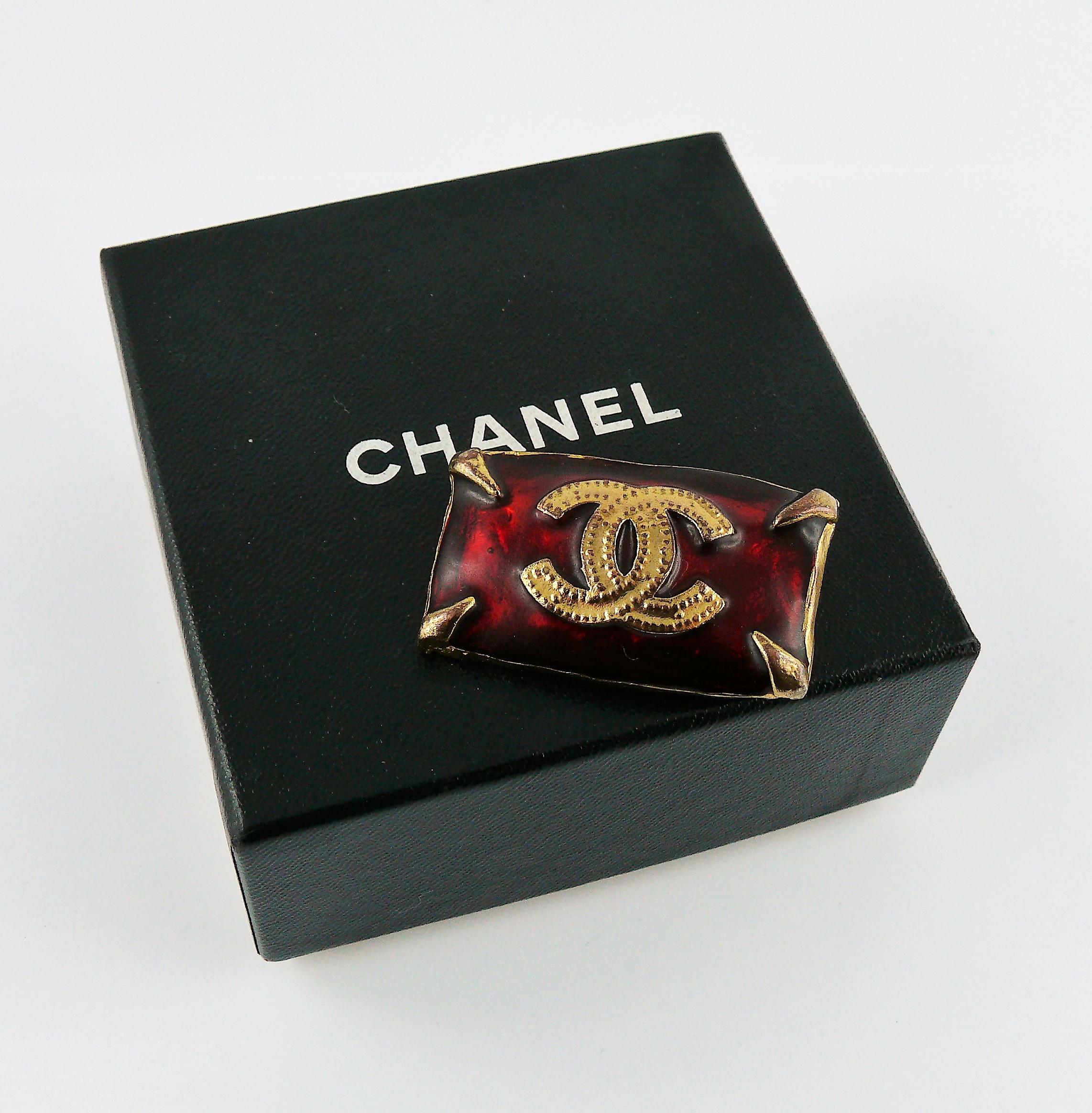 CHANEL vintage gold toned rectangular brooch featuring a large CC logo on a red enamel background.

Embossed CHANEL Made in France.

Indicative measurements : length approx. 3.9 cm (1.54 inches) / width approx. 2.3 cm (0.91 inch).

Comes with a