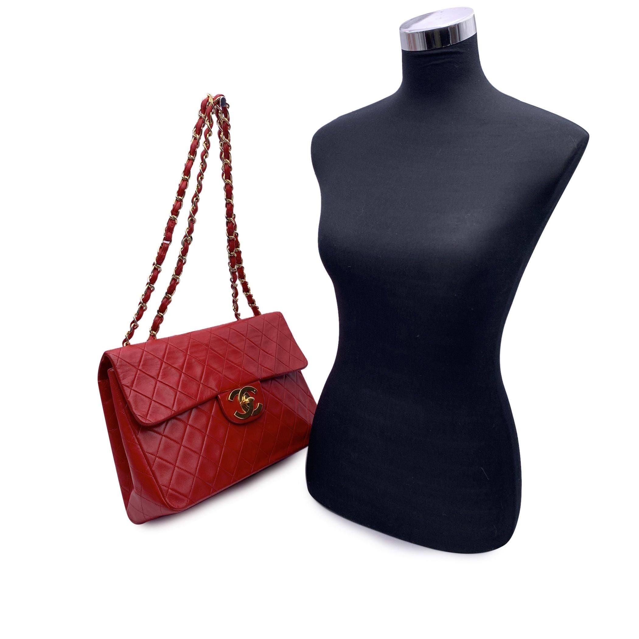 Vintage Chanel 'Jumbo' Timeless Classic Flap 2.55 Bag in red quilted leather. Period/Era: 1991 -1994. It features double 'CC' turn lock closure and interwoven chain/leather straps; can be worn on the shoulder with double strap or lengthen to wear